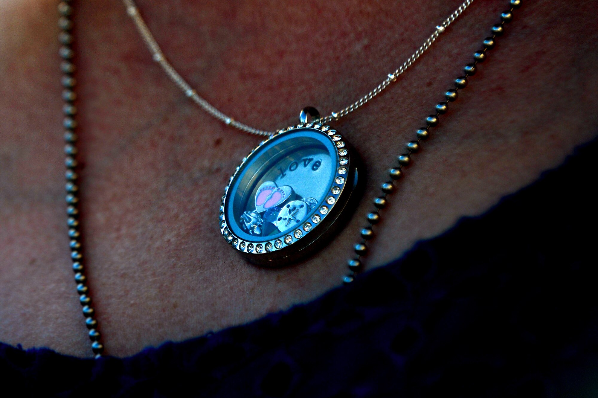 Edith Grabowsky, wife of Tech. Sgt. Kevin Grabowsky, 20th Equipment Maintenance Squadron production supervisor, wears a charm necklace from her husband while waiting for him to return from deployment, April 25, 2013, Shaw Air Force Base, S.C. The necklace was her first Mother’s Day present. It has a “G” for Grabowsky, a cat to represent their four pets and pink feet for their unborn daughter. (U.S. Air Force photo by Airman 1st Class Nicole Sikorski/Released)