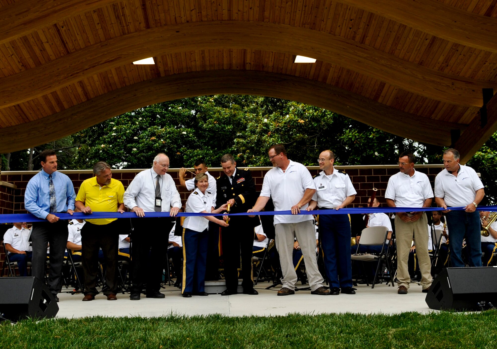 U.S. Army Maj. Gen. Mark MacCarley, center, U.S. Army Training and Doctrine Command deputy chief of staff, is joined by TRADOC band members, architects, planners and engineers during the ribbon cutting for the new TRADOC band stage in Magnolia Park at Fort Eustis, Va., June 6, 2013. The ribbon cutting took place before the band’s “Music Under the Stars” summer concert series kickoff event. (U.S. Air Force photo by Staff Sgt. Wesley Farnsworth / Released) 