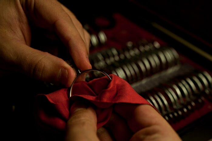 U.S. Air Force Staff Sgt. Christopher Hutchinson, 99th Aerospace Medicine optometry flight chief, cleans the dust off lenses June 7, 2013, at Nellis Air Force Base, Nev. The lenses help the eye care professional select the correct prescription for patients’ eyes. (U.S. Air Force photo by Senior Airman Daniel Hughes)