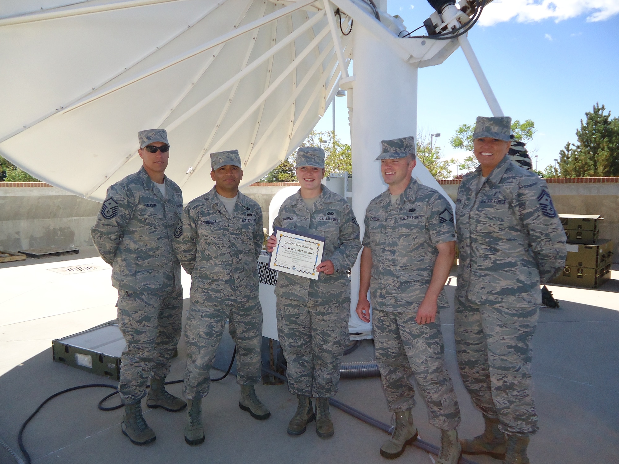 PETERSON AIR FORCE BASE, Colo. -- Staff Sgt. Karla McCormick (center), Space and Missile Systems Center, was selected by the Pikes Peak Top 3 for the Sharp Warrior Award. McCormick was selected for her work in Materiel Management for MilSatCom Logistics and Sustainment. The award recognizes Airmen who go beyond their everyday tasks and demonstrate a high level of excellence, specifically in customer service and professional appearance. Any first sergeant or senior NCO serving as a first sergeant who observes outstanding performance may nominate someone for the award to the first sergeants council. (U.S. Air Force photo)