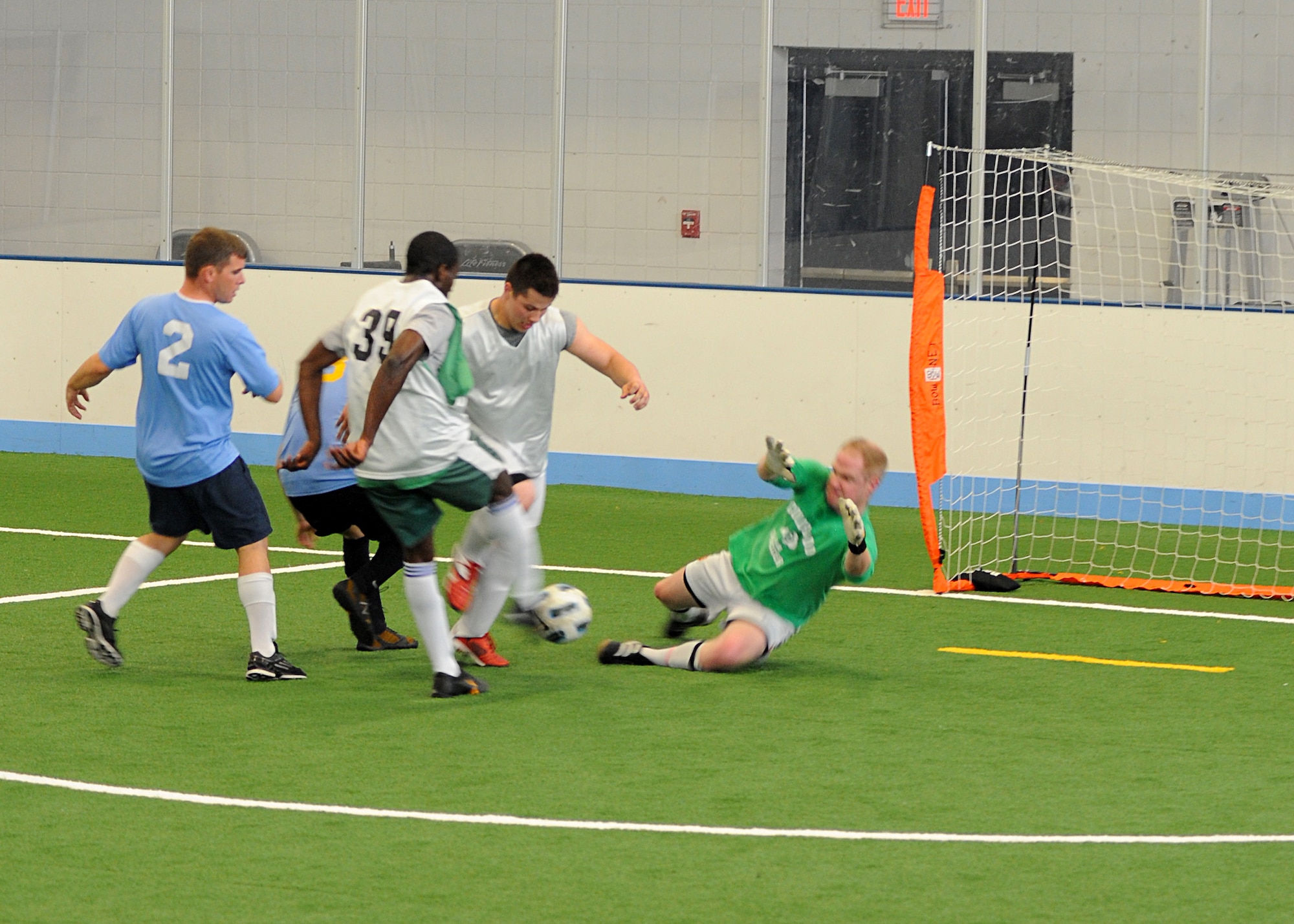 Members of the 319th Logistics Readiness Squadron soccer team (white jersey) attempts to score a goal against the goalie, May 30, 2013, at the Fitness Center, on Grand Forks Air Force Base, N.D. LRS defeated their opponents 4-3. (U.S. Air Force photo/Airman 1st Class Xavier Navarro) 