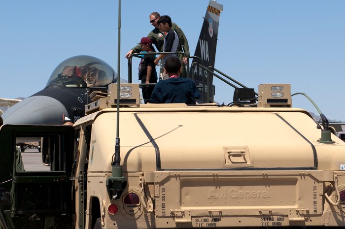 Capt. John Harris, 64th Aggressor Squadron pilot, answers questions from survivors of childhood cancer and their siblings about the F-16 Fighting Falcon June 8, 2013, at Nellis Air Force Base, Nev. Airmen from the 64th AGRS and several other Nellis units volunteered to spend their Saturday with the Candlelighters Childhood Cancer Foundation of Nevada to provide static displays for the children and give them a tour of the base. (U.S. Air Force Photo by Staff Sgt. Gregory Brook)