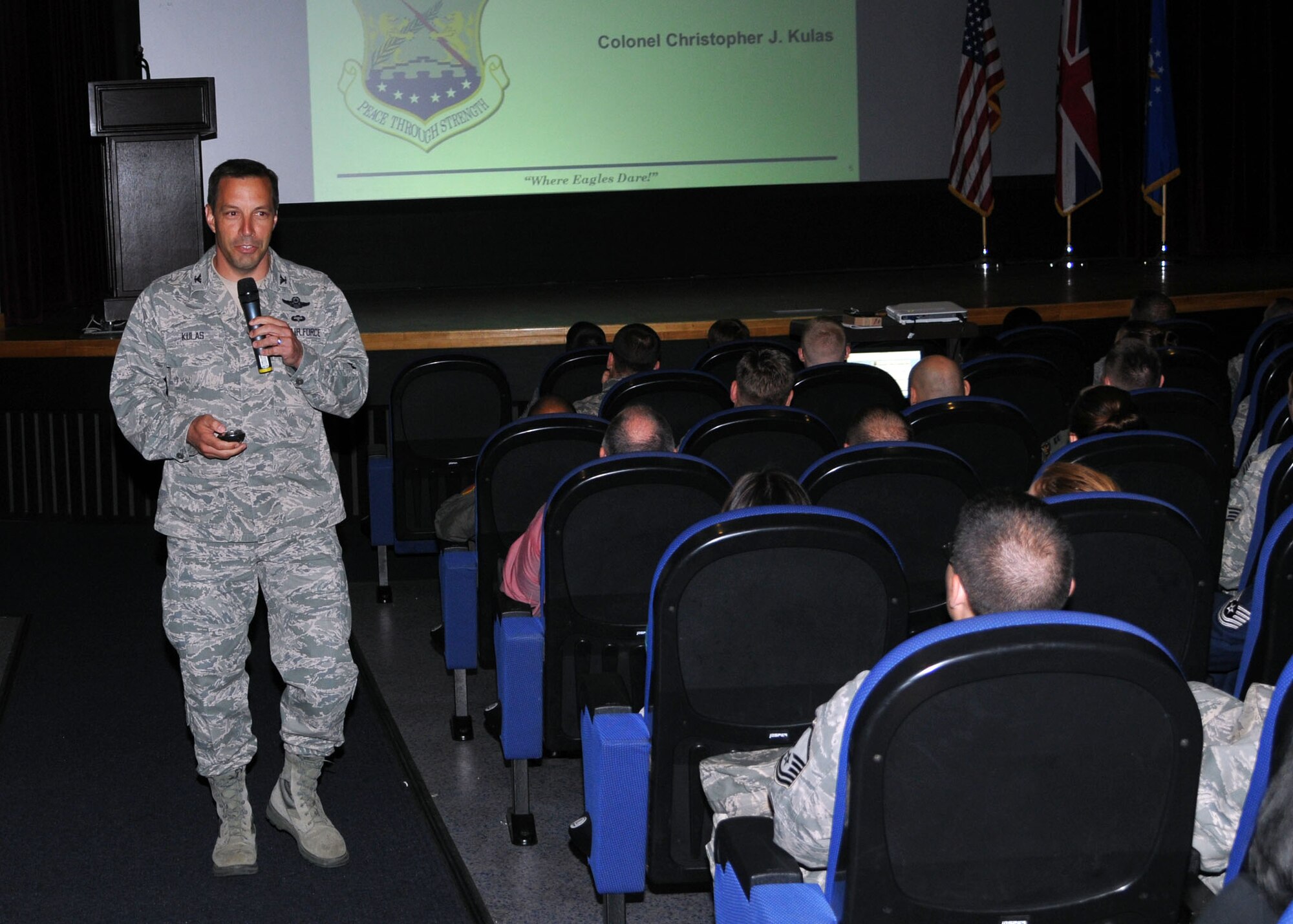 Col. Christopher Kulas, 100th Air Refueling Wing commander, gives a briefing on events from the previous quarter and the way ahead for Team Mildenhall June 11, 2013, at the base theater on RAF Mildenhall, England. The commander’s call, held four times throughout the day, was Kulas’ last on RAF Mildenhall before he departs for his new assignment. (U.S. Air Force photo by Airman 1st Class Kelsey Waters/Released)