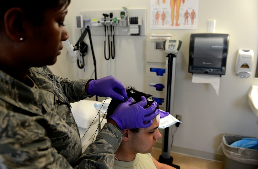 U.S. Air Force Tech. Sgt. Valarie Platt, 633rd Medical Operations Squadron Neurology Clinic noncommissioned officer in charge, places an electrode on Airman 1st Class Christopher Howell, 633rd MDOS medical technician, prior to an electroencephalography (EEG) study at U.S. Air Force Hospital Langley at Langley Air Force Base, Va., May 4, 2013. The clinic is one of nine neurological clinics in the Air Force and boasts a staff that provides a wealth of knowledge to offer specialized neurological services (U.S. Air Force photo by Airman 1st Class R. Alex Durbin/Released)