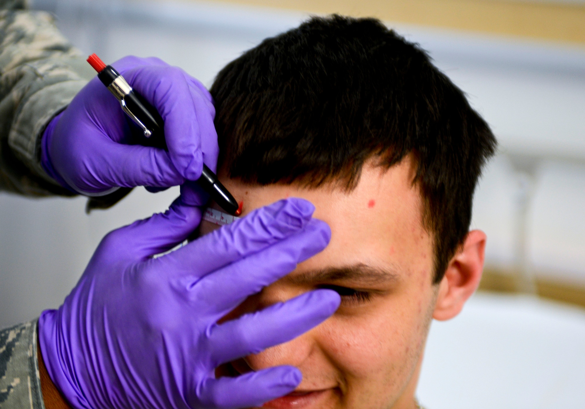 U.S. Air Force Tech. Sgt. Valarie Platt, 633rd Medical Operations Squadron Neurology Clinic noncommissioned officer in charge, marks the forehead of Airman 1st Class Christopher Howell, 633rd MDOS medical technician, prior to an electroencephalography (EEG) study at U.S. Air Force Hospital Langley at Langley Air Force Base, Va., May 4, 2013. The clinic offers consultations for patients experiencing persistent headaches, numbness or pain, unconsciousness, difficulty walking, moving or balancing, abnormal vocal tone or memory loss. (U.S. Air Force photo by Airman 1st Class R. Alex Durbin/Released)