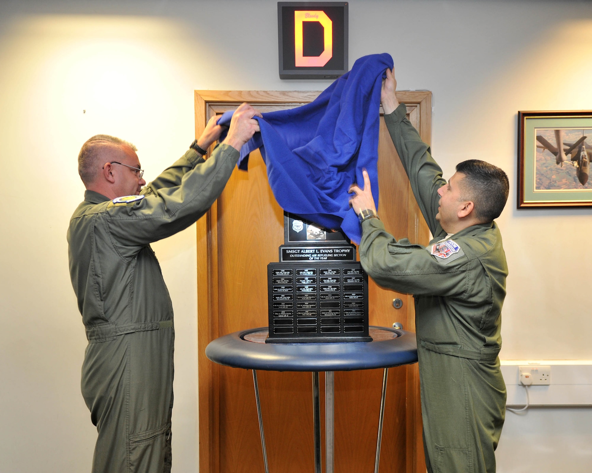 From right, Master Sgts. Michael Rodriguez, 351st Air Refueling Squadron operations superintendent from Victoria, Texas, and Clinton Slick, 351st ARS first sergeant from Hot Springs, Ark., unveil the Senior Master Sgt. Albert L. Evans Outstanding Refueling Section of the Year award June 11, 2013, at RAF Mildenhall, England. The 351st ARS earned the award for their accomplishments throughout 2012, including the execution of more than 1,500 sorties culminating in more than 6,700 flying hours. (U.S. Air Force photo by Staff Sgt. Jerilyn Quintanilla/Released)