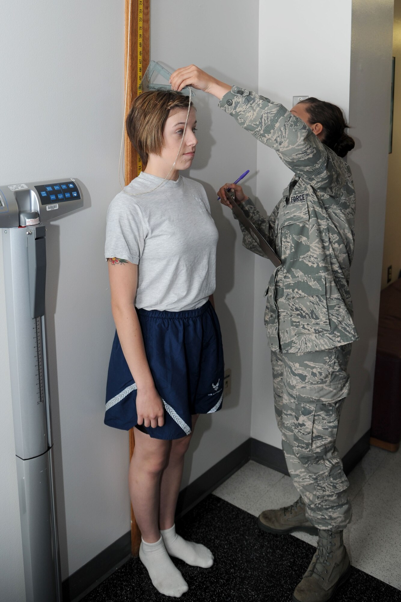 Senior Airman Alicia Foster, 442nd Services Flight technician, measures the height of Senior Airman Allie Cantwell, 442nd Aerospace Ground Equipment technician, while administering a physical training test June 8, 2013. The 442nd Services Flight is part of the 442nd Force Support Squadron within the 442nd Fighter Wing, an A-10 Thunderbolt II Air Force Reserve Unit at Whiteman Air Force Base, Mo. (U.S. Air Force photo by Senior Airman Mike Addis/Released)