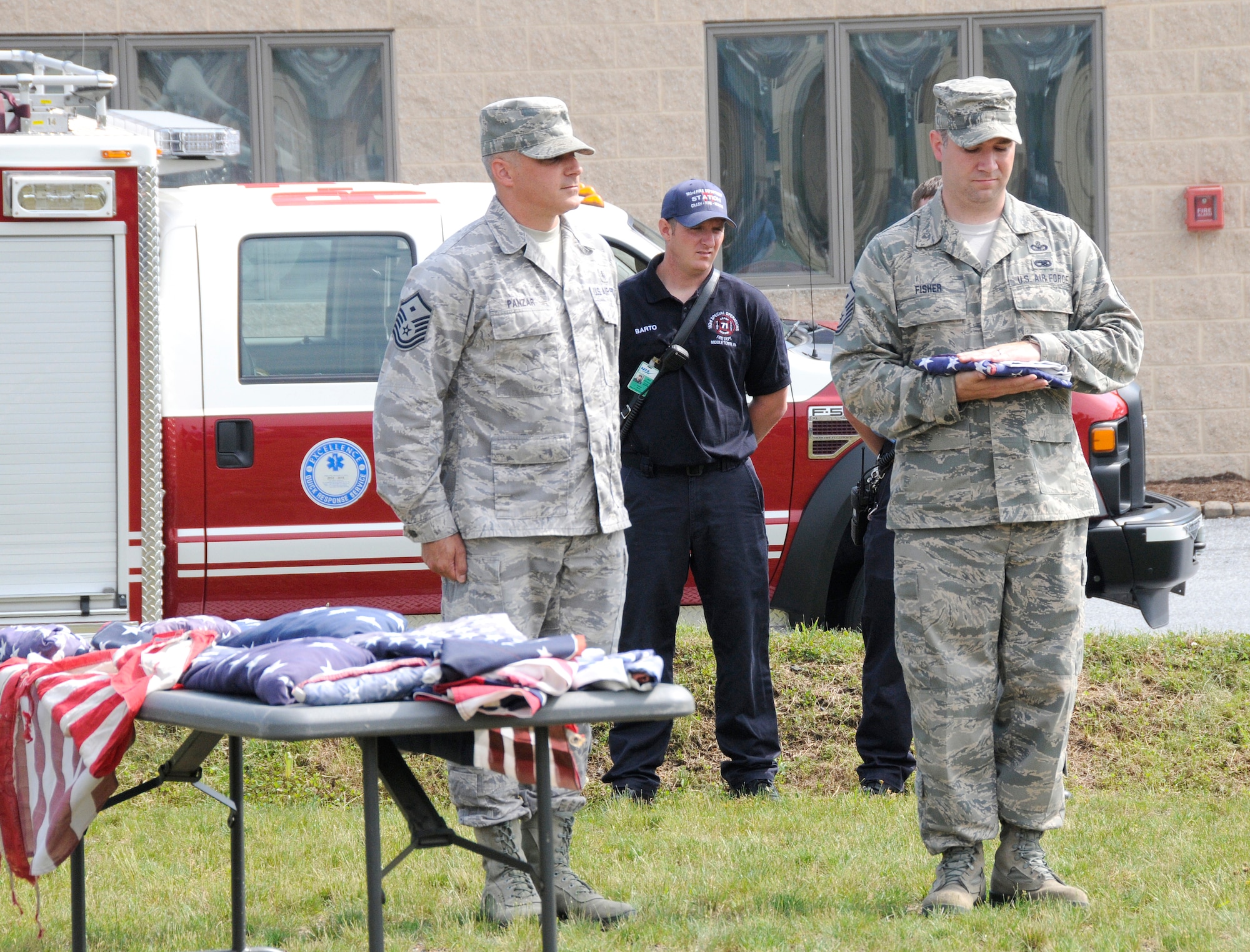 Master Sgts. Richard Panzar (left) and Jeremy Fisher (right), both first sergeants at the 193rd Special Operations Wing, prepare an unserviceable flag to be retired during a flag retirement ceremony held on base June 9. (U.S. Air National Guard photo by Staff Sgt. Susan Penning/Released)