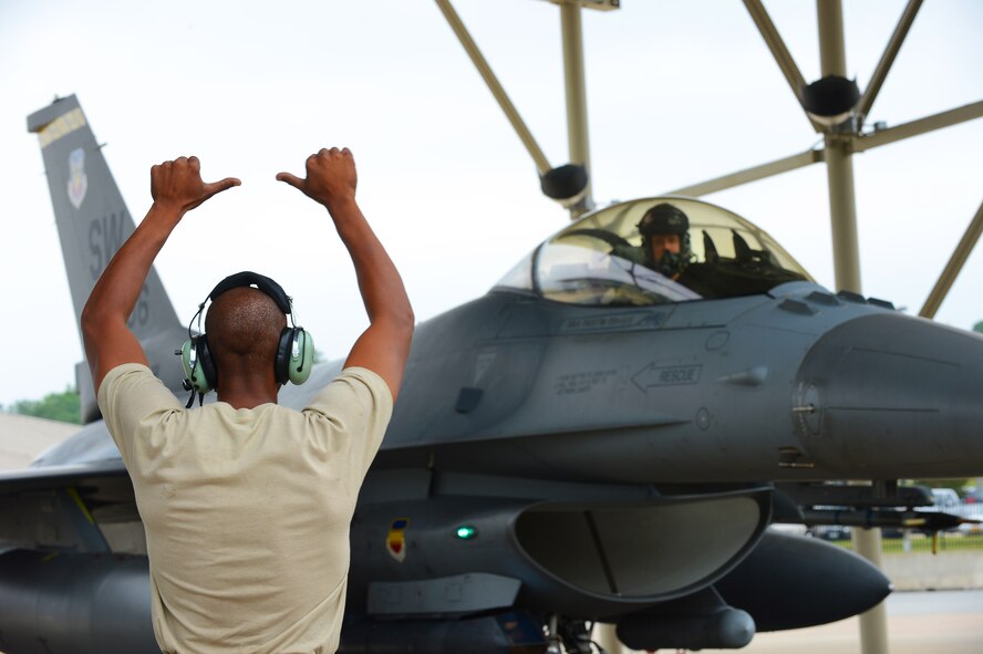U.S. Air Force Staff Sgt. Edward Watkins, 77th Fighter Squadron crew chief, recovers an F-16 Fighting Falcon at Shaw Air Force Base, S.C., June 5, 2013. The 77th crew chiefs work around- the-clock, launching and recovering F-16s for training and real-world combat scenarios. (U.S. Air Force photo by Airman 1st Class Nicole Sikorski/Released) 