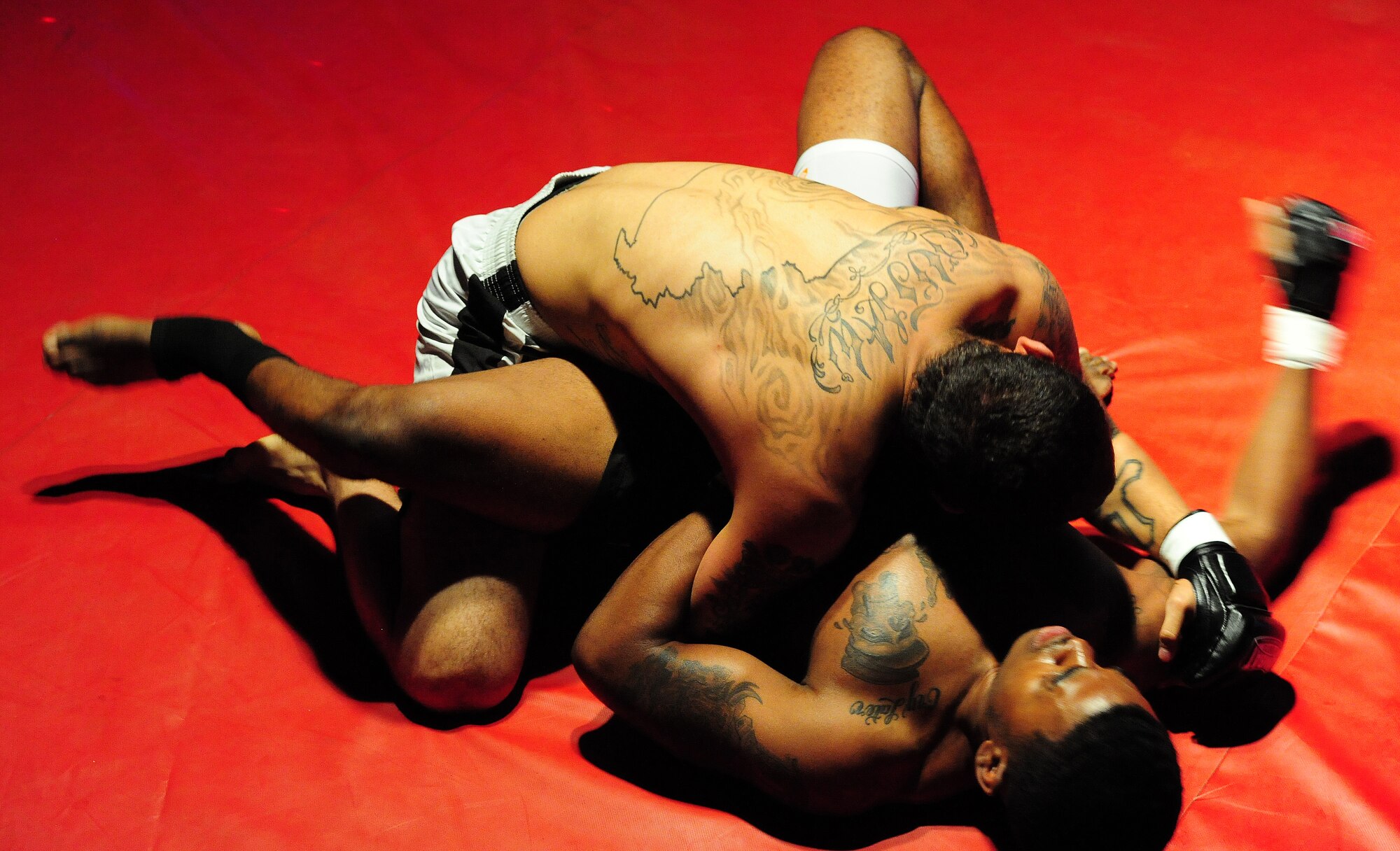Steven Dickerson, bottom, 509th Maintenance Squadron low observable structural maintenance technician, throws punches to the face of Chalen Chaney during an amateur mixed martial arts match at Bottoms Up in Sedalia, Mo., May 18, 2013. Mixed martial arts is a full-contact sport allowing the use of striking and grappling techniques, and the only way to win is by knockout or tapout. (U.S. Air Force photo by Staff Sgt. Nick Wilson/Released)