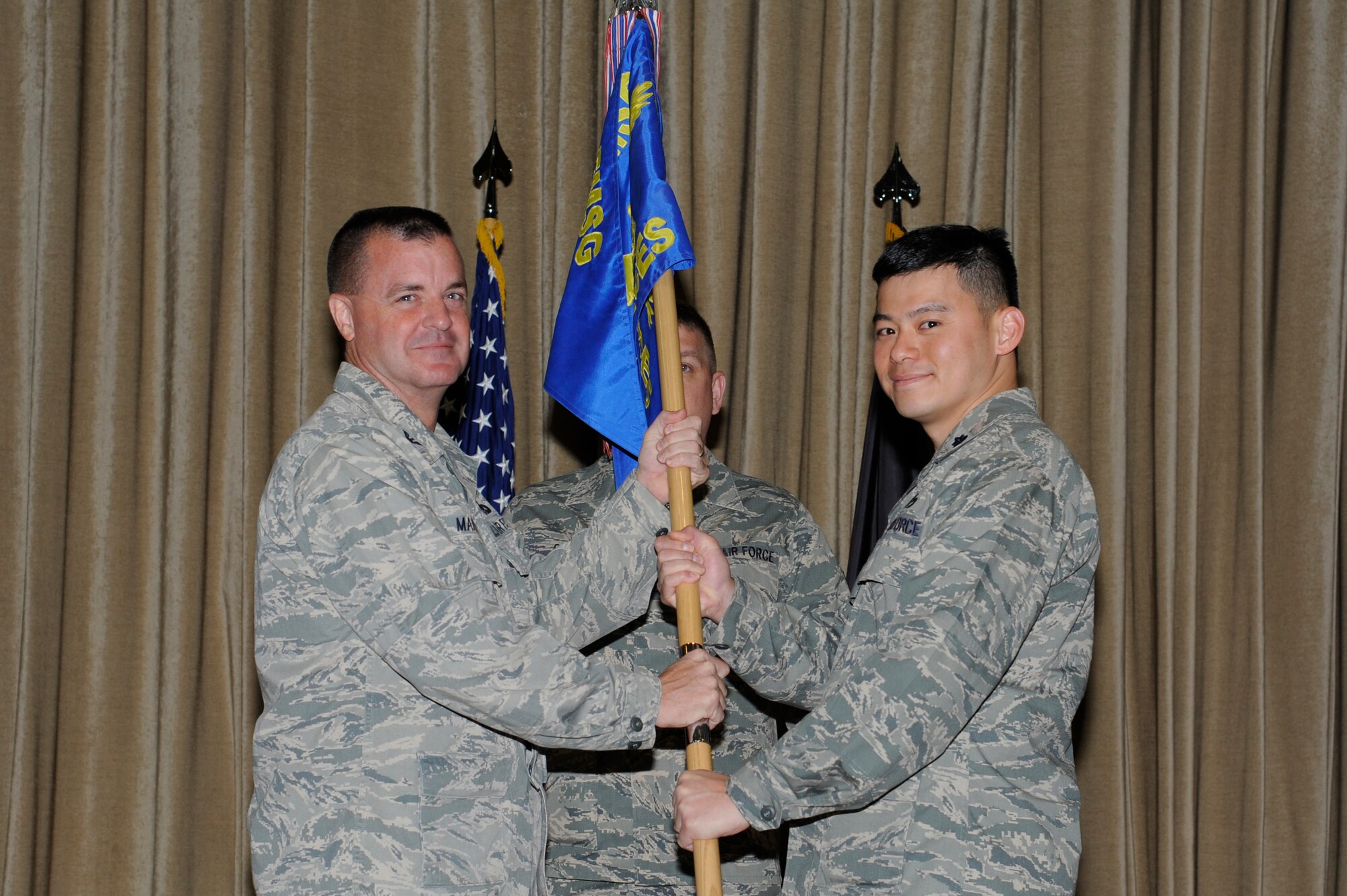 U.S. Air Force Col. Joseph Martin, 386th Expeditionary Mission Support Group commander, left, passes the 386th Expeditionary Civil Engineer Squadron guidon to Lt. Col. Chen Yen Su during a change of command ceremony June 11, 2013 at an undisclosed location in Southwest Asia.  Lt. Col. Su assumed command of the 386th ECES from Lt. Col. Kyle Brown.  (U.S. Air Force photo by Staff Sgt. Austin Knox)