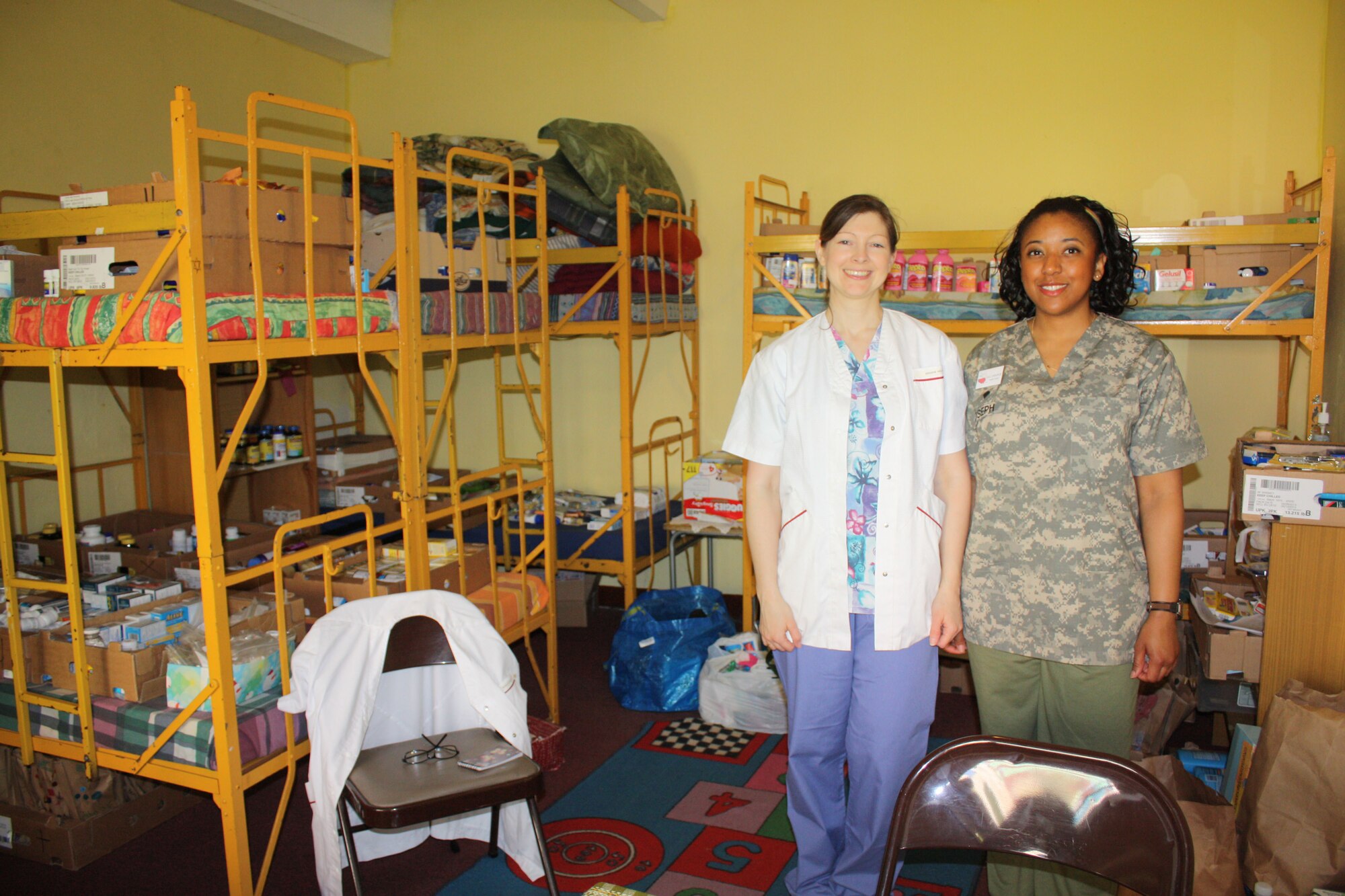 LWOWEK SLASKI, Poland – Colene Bradley (left) from Spangdahlem and Spc. Julianne Joseph, a medic from the 15th Engineer Battalion, HHC in Sweinfurt, Germany, pose in the makeshift pharmacy they helped set up while sorting through and organizing the donated medicines and supplies. The Hearts for Elim mission trip focused on bringing medical healing as well as attending to the spiritual needs of the patients throughout the surrounding communities of Lwowek Slaski, Poland. (U.S. Air Force courtesy photo/Released)
