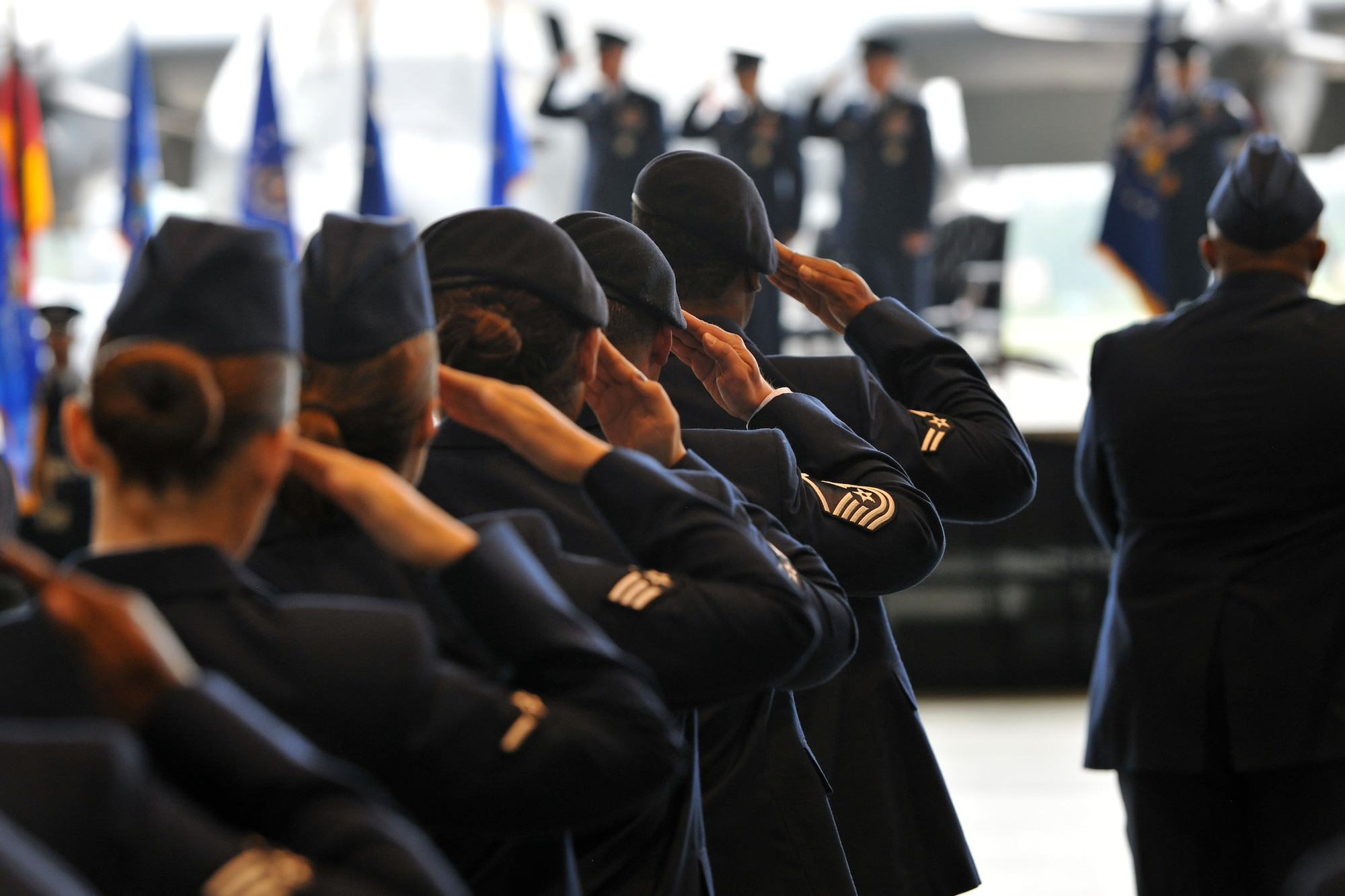 Airmen salute while the base honor guard posts the colors during the 86th Airlift Wing change of command ceremony, June 10, 2013, Ramstein Air Base, Germany. Brig. Gen. Patrick X. Mordente assumed command of the largest wing in Europe from Brig. Gen. C.K. Hyde. (U.S. Air Force photo/Senior Airman Chris Willis)