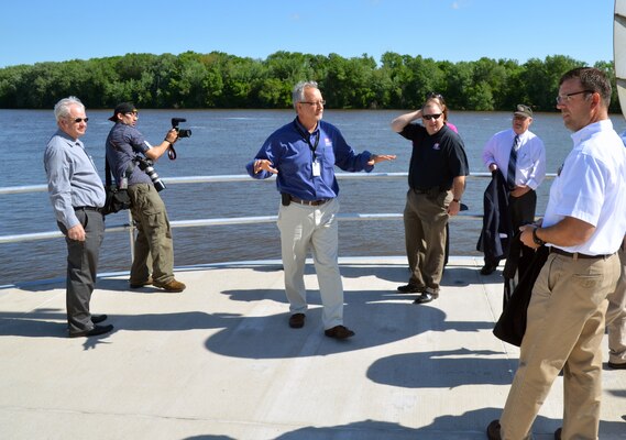 Tom Novak, project manager for the recently completed Lock and Dam 3 Navigation Safety and Embankment Improvements project talks with stakeholders and partners at the end of the 862-foot upstream guide wall. A rededication ceremony was held at the facility May 31, signifying the completion of the nearly $70 million dollar project that significantly improves the navigational safety of boats entering the lock.