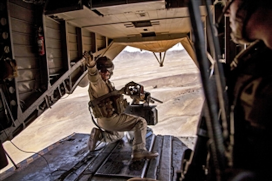 A U.S. Marine gives a signal during a clearing operation over Nowzad in Afghanistan's Helmand province, June 6, 2013. The Marine, a crew chief, is assigned to Marine Heavy Helicopter Squadron 46. Afghan soldiers led the operation and the U.S. Marines supported it as part of an overall effort in which U.S. and coalition troops are working with Afghan forces to transition to Afghan-led operations in the country.