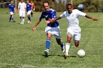 Cpl. Bryant Haskinjames, a foward for the Marine Corps team, fights off a defender as he dribbles toward during the 2012 Armed Force Men's Soccer Tournament at the 11 Area Parade Deck, Sept. 26. The Air Force team defeated the Marine Corps team 2-1, handing the Marines their first loss of the tournament.