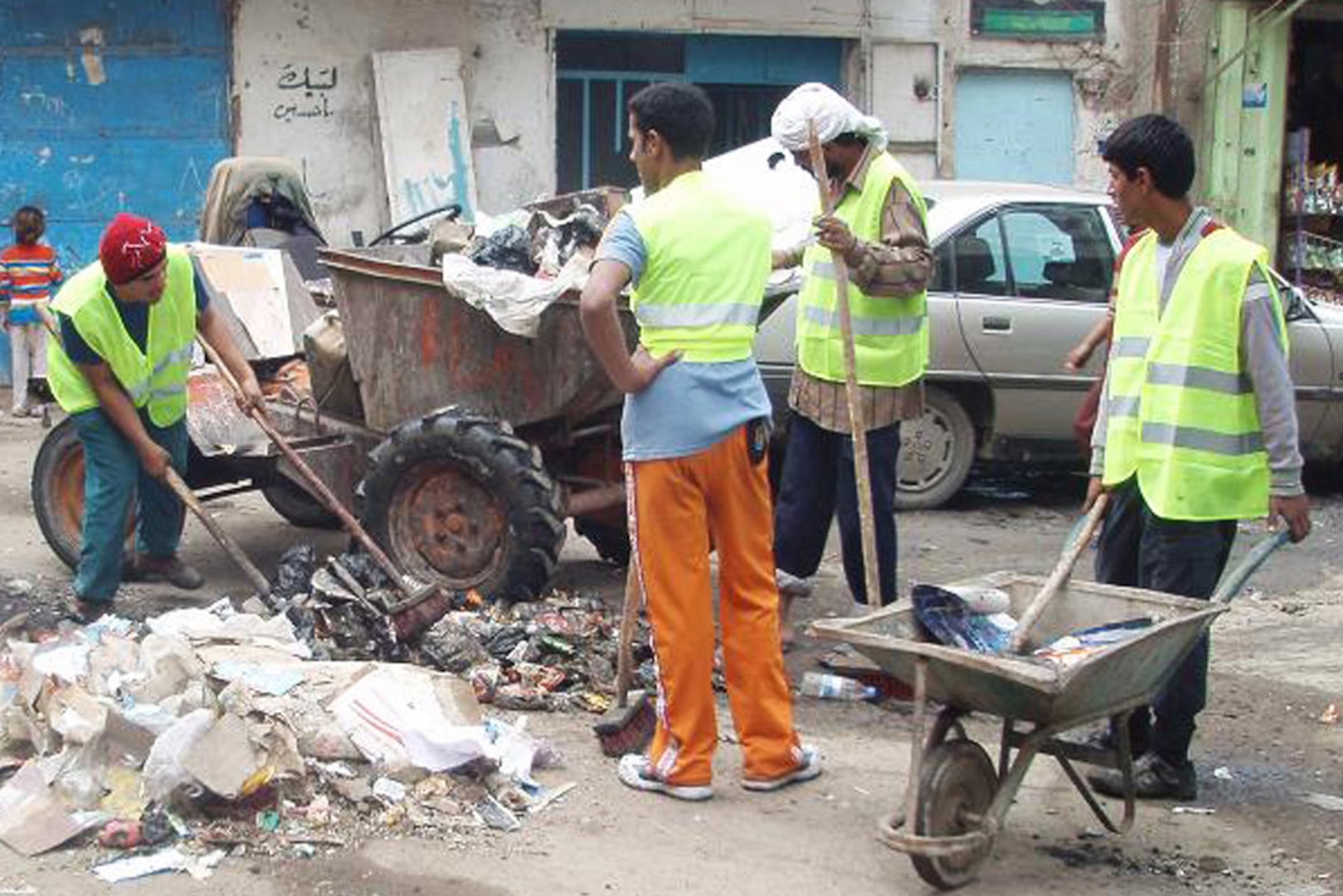 Residents of Baghdad's Rusafa district working for an Iraqi company clean up trash on a street Nov. 23, 2008. Leaders of Task Force Gold Spike contracted the company to remove trash as part of a mandate to improve living conditions for the people of Rusafa.