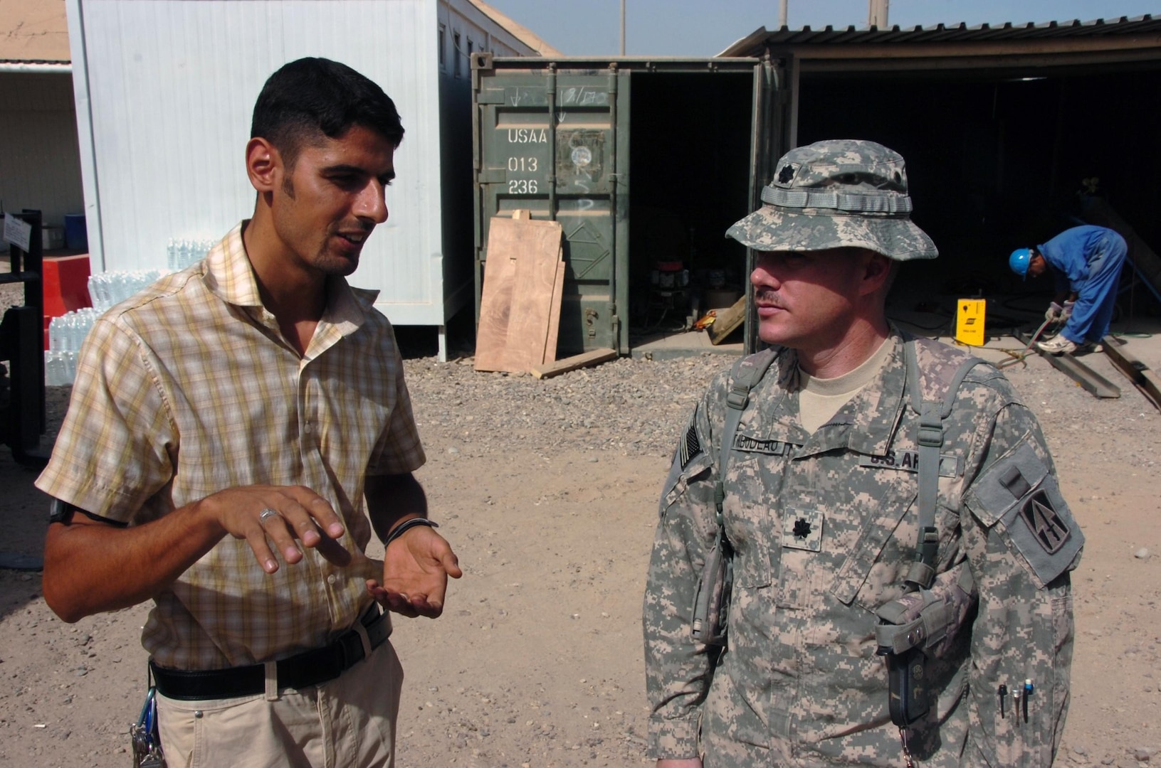 Brigade Combat Team as project manager with the Iraqi-Based Industrial Zone at Joint Base Balad, talks on Oct. 19, 2008, with Hiadel Hassah, project manager for an Iraqi business that refurbishes shipping containers on base. I-BIZ is a designated secure area on a coalition base where a variety of Iraqi businesses can operate, and the Indiana National Guard spearheaded the I-BIZ effort at Joint Base Balad.