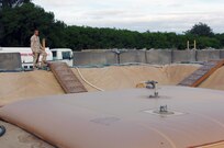 Air Force Master Sgt. James Butts observes the filling of a fuel bladder at Joint Task Force Guantanamo's Camp Justice, Nov. 24, 2008. These 10,000 gallon bladders are filled five times a week to ensure continuous power is maintained at Camp Justice and the Expeditionary Legal Complex. JTF Guantanamo conducts safe, humane, legal and transparent care and custody of detained enemy combatants, including those convicted by military commission and those ordered released. The JTF conducts intelligence collection, analysis and dissemination for the protection of detainees and personnel working in JTF Guantanamo facilities and in support of the Global War on Terror. JTF Guantanamo provides support to the Office of Military Commissions, to law enforcement and to war crimes investigations. The JTF conducts planning for and, on order, responds to Caribbean mass migration operations.