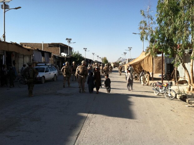 Marines with the Civil Affairs Detachment, Regimental Combat Team 7, walk through the district center in Now Zad, May 31, 2013. "They're able to provide commanders with intelligent information about politics in the district," said Maj. Stefan Sneden, the detachment deputy officer-in-charge.  "We're trained to focus on the government and politics and then provide the commander with guidance." (Courtesy photo)
