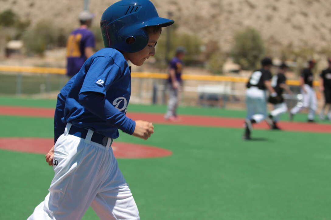 John Coronado runs to first base in the Miracle League of the Desert's opening day celebration after the 2013 Grubstake Days Parade in Yucca Valley.