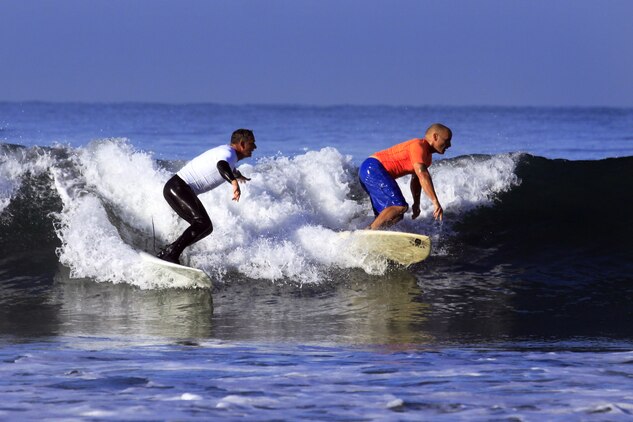 Col. Paul Miller with Headquarters and Support Battalion, Marine Corps Installations West, left, and Norm Norred with Assault Craft Unit 5, right, compete to see who can ride the wave longer during the 6th annual 2013 USAA Commanding General's Surf Competition at the San Onofre Beach here, June 11. After riding a total of six waves, the top two waves are taken for each competitors score.