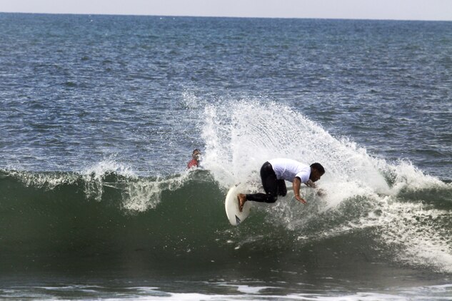 Petty Officer 1st Class Randy Adalin from 1st Medical Battalion rides a wave during the 6th annual 2013 USAA Commanding General's Surf Competition at the San Onofre Beach here, June 11. Competitors were judged on wave selection, time on the wave and tricks they perform.