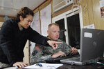 Army Pfc. Steven P. Fitzgerald and his fiancé, Army Spc. Viviana B. Molina, of the 3-142nd Assault Helicopter Battalion, review intelligence reports before a briefing in Iraq. Fitzgerald, an 18-year veteran of the New York City Fire Department, joined the National Guard when he was 41 years old. 