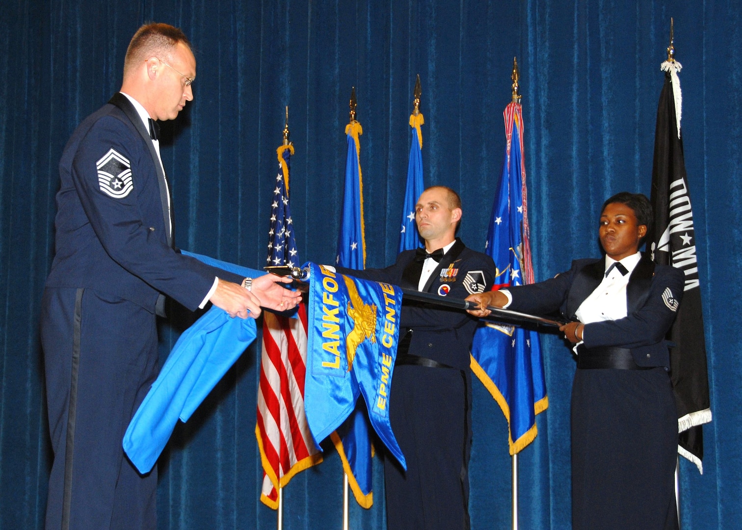 Air National Guard members Senior Master Sgt. Timothy J. Kumes, Master Sgt. Paul G. Rayman, and Tech. Sgt. Jeela S. Matthews perform a guidon exchange ceremony at The I. G. Brown Air National Guard Training and Education Center to signify the transition of the ANG EPME branch to its new name as the Paul H. Lankford Enlisted Professional Military Education Center December 16, 2008.