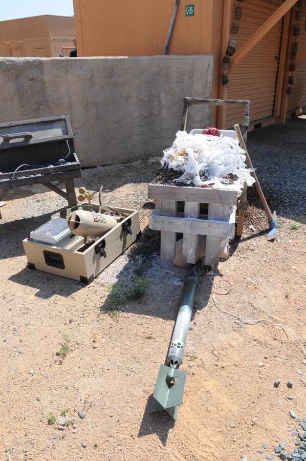 During a May 30, 2013, demonstration of the Training Support Center’s improvised explosive device simulators at Quantico’s Urban Training Center, the Explotrain XO4 unit on the left created the “boom,” while a device in the fake mortar round in front of the cart threw up a cloud of talcum powder, imitating smoke. 