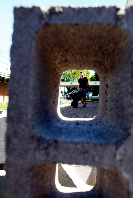 A Casuarina Senior College student and member of the Clontarf Foundation pushes a wheelbarrow full of cinder blocks to the gardening site at the school, here, May 30. Marines with Marine Rotational Force - Darwin helped students with the foundation build a vegetable garden funded by the Consulate General of the United States, Melbourne MRF-D Marines volunteer at the school every Thursday to help with these types of projects and provide mentorship.