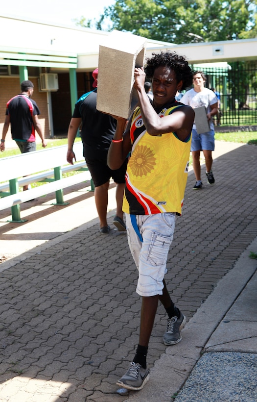 Michael Lindsay, a Casuarina Senior College student and member of the Clontarf Foundation, lifts a cinder block to the gardening site at the school, here, May 30. Marines with Marine Rotational Force - Darwin helped students with the foundation build a vegetable garden funded by the Consulate General of the United States, Melbourne. MRF-D Marines volunteer at the school every Thursday to help with these types of projects and provide mentorship.