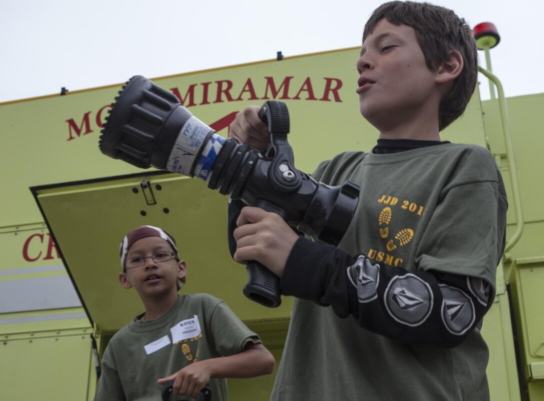 A child looks at a nozzle used for hoses by Aircraft Rescue and Firefighting Marines during a Junior Jarhead Day hosted by Marine Aircraft Group 16 aboard Marine Corps Air Station Miramar, Calif., June 8. Junior Jarhead Day teaches military children about their parents’ jobs and allows them to meet new friends.