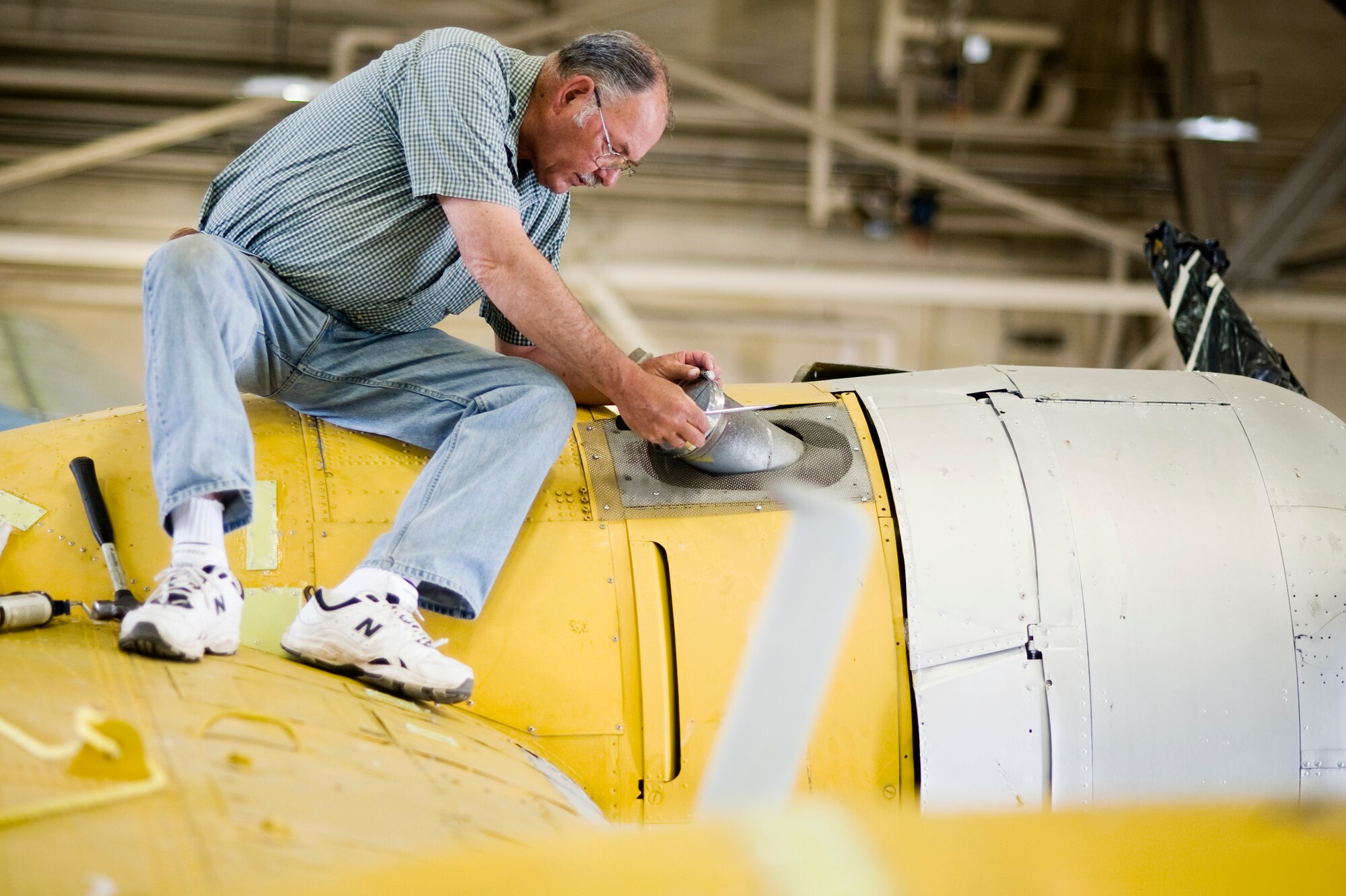 Master Sgt. (ret.) Richard King blocks the exhaust of a SA-10 Catalina to help waterproof the engines, May 18, 2010 at Joint Base Lewis-McChord, Wash. King worked as a supply troop in the Air Force for 25 years. This aircraft is representative of the SA-10 Catalina rescue airplane that was stationed at McChord Field as part of the 43rd Air Rescue Squadron in the late forties. (U.S. Air Force photo/Abner Guzman)