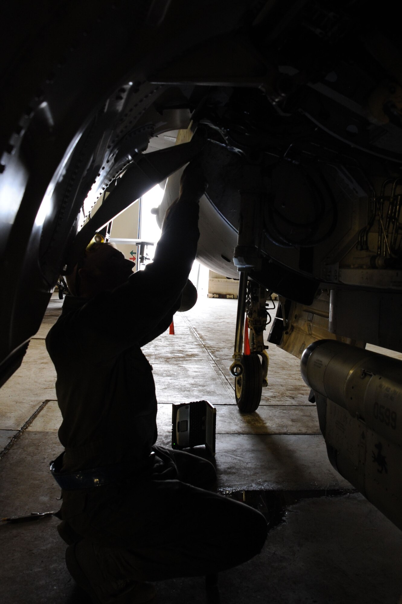 U.S. Air Force Staff Sgt. Michael Schaefer, 35th Aircraft Maintenance Squadron, works on the main landing gear door of a U.S. Air Force F-16 Fighting Falcon during an Operational Readiness Exercise at Misawa Air Base, Japan, June 12, 2013. Schaefer said the intensity and pace of base exercises provides all squadron members valuable experience in maintenance preparation. (U.S. Air Force photo by Senior Airman Derek VanHorn)
