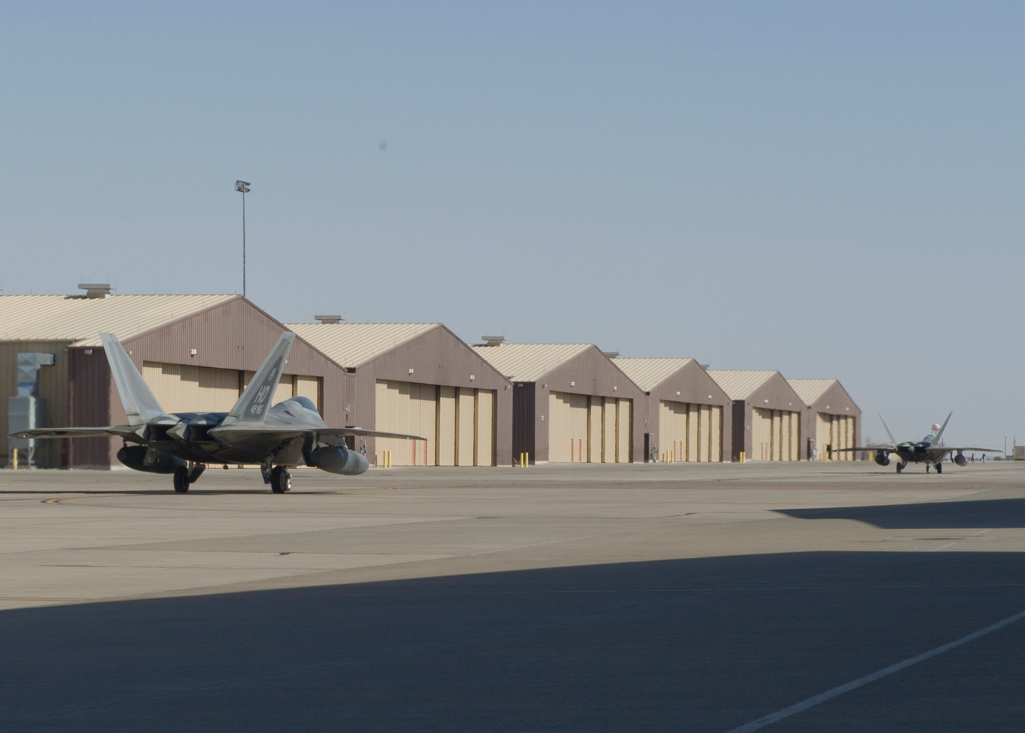 Two F-22 Raptors from the 7th Fighter Squadron taxi to the runway at Holloman Air Force Base, N.M., June 7. The 7th FS flew F-22s in support of Operation Noble Eagle. ONE is the name given to the United States and Canadian military operations related to homeland security and support to federal, state, and local agencies. The ongoing operation began September 14, 2001, in response to the September 11 attacks. (U.S. Air Force photo by Airman 1st Class Aaron Montoya /Released)