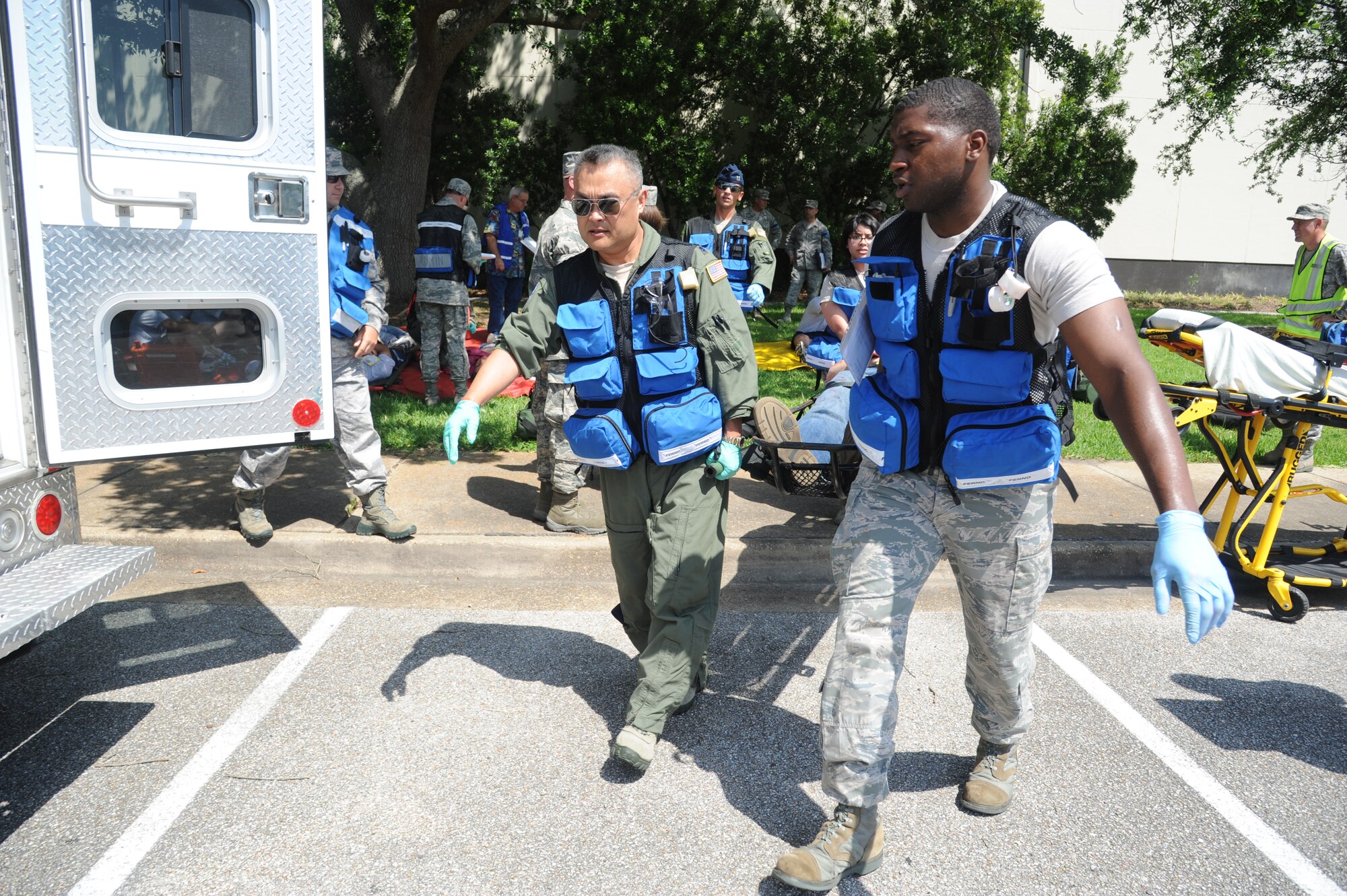 Lt. Col. Johan Ahn and Staff Sgt. Ryan Wallace, 81st Aerospace Medicine Squadron, assist in carrying a litter on to an ambulance to be transported to the Keesler Medical Center during Keesler's active shooter exercise, June 12, 2013, at Garrard Hall, Keesler Air Force Base, Miss.  During the two-day exercise, an Air Force couple simulated opening fire, killing three people and injuring 41.  The exercise tested the base's ability to respond to and recover from a mass casualty event.  (U.S. Air Force photo by Kemberly Groue)