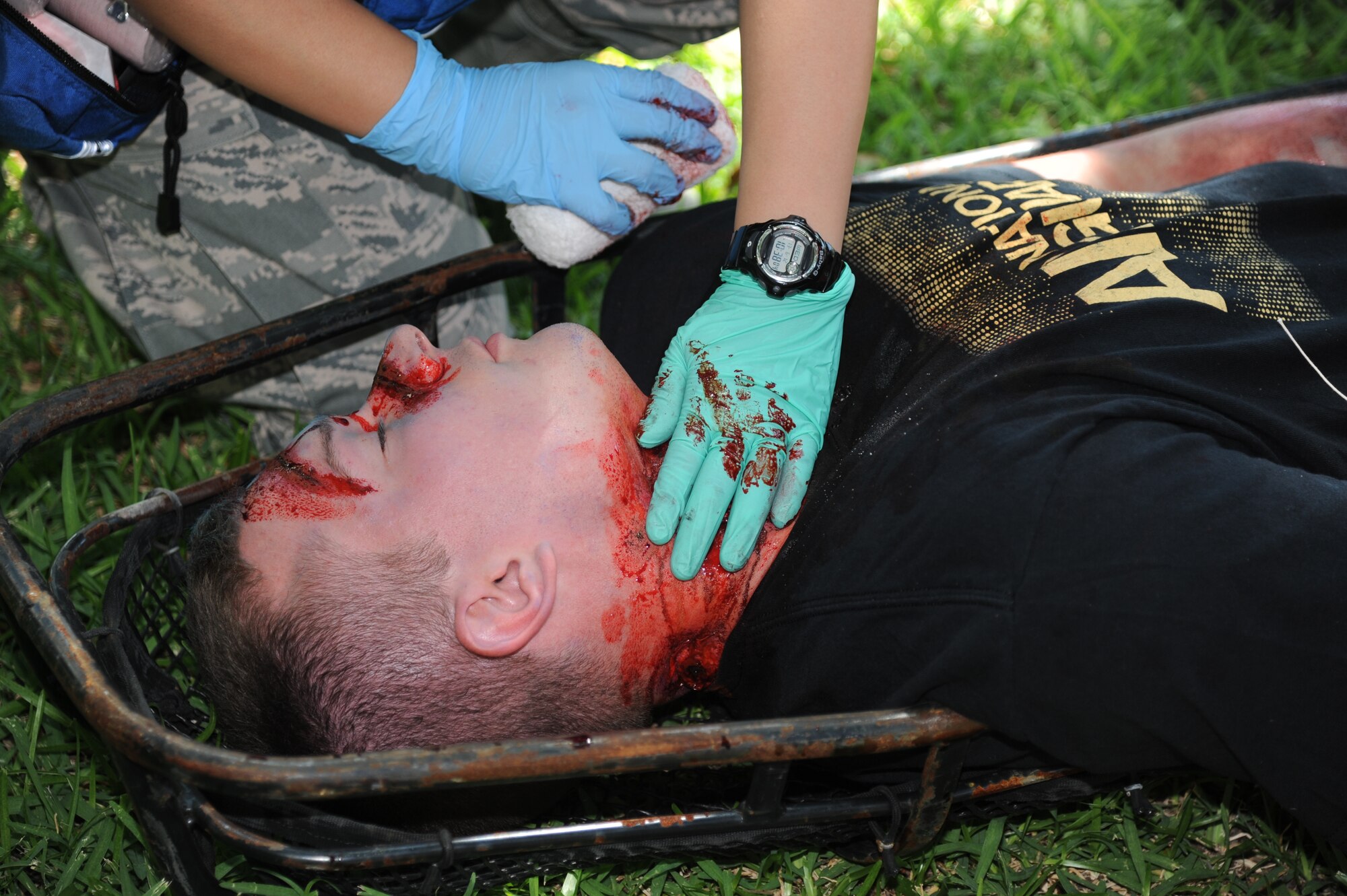 First Lt. Ryan Rickert, 333rd Training Squadron, receives simulated triage from members of the 81st Medical Group for gunshot wounds during Keesler's active shooter exercise, June 12, 2013, at Garrard Hall, Keesler Air Force Base, Miss.  During the two-day exercise, an Air Force couple simulated opening fire, killing three people and injuring 41.  The exercise tested the base's ability to respond to and recover from a mass casualty event.  (U.S. Air Force photo by Kemberly Groue)