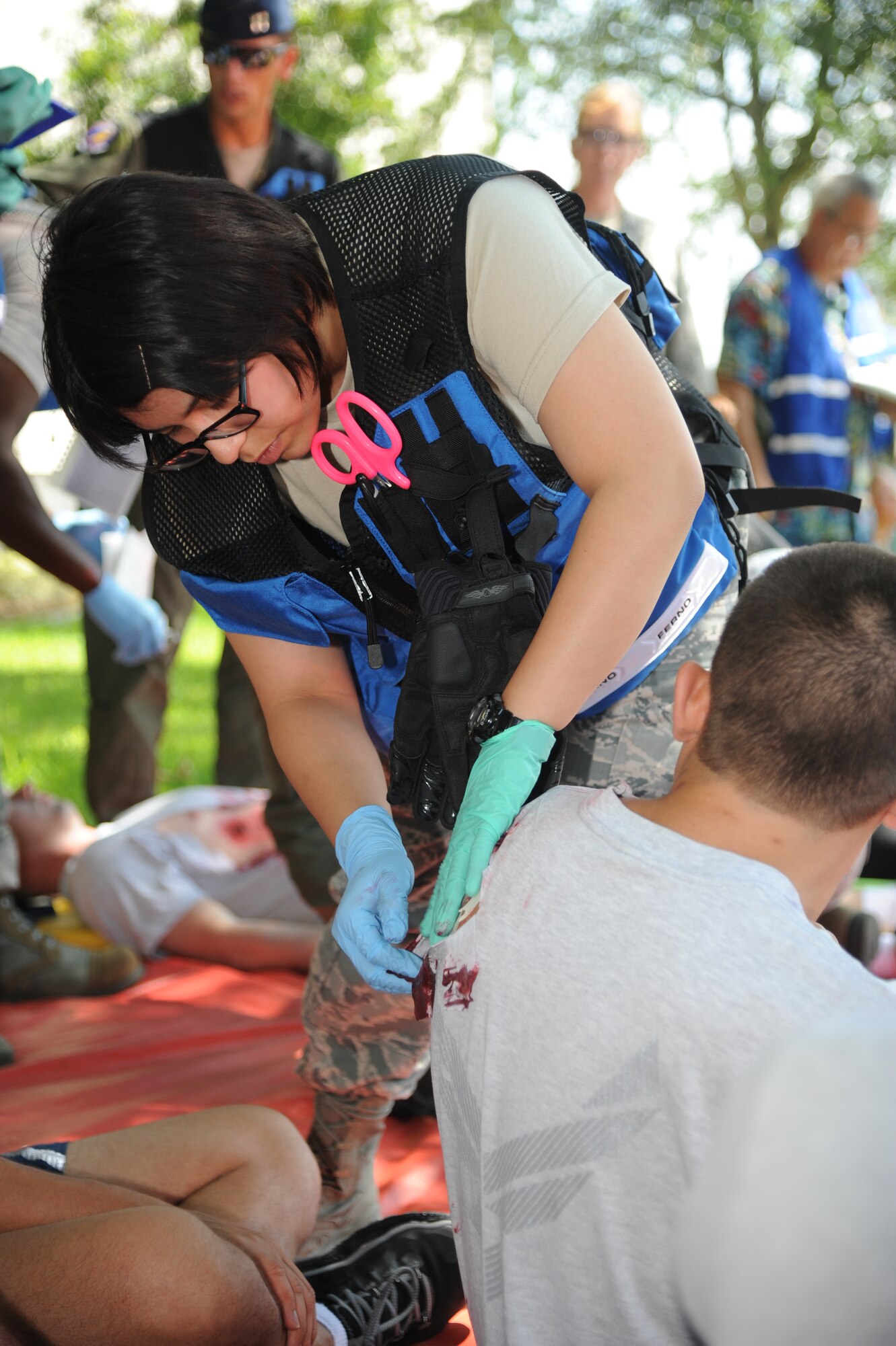 Airman 1st Class Claudia Godinez, 81st Aerospace Medicine Squadron, administers simulated triage to a gunshot wound on 1st Lt. Gabriel Necoche, 333rd Training Squadron, during Keesler's active shooter exercise, June 12, 2013, at Garrard Hall, Keesler Air Force Base, Miss.  During the two-day exercise, an Air Force couple simulated opening fire, killing three people and injuring 41.  The exercise tested the base's ability to respond to and recover from a mass casualty event.  (U.S. Air Force photo by Kemberly Groue)