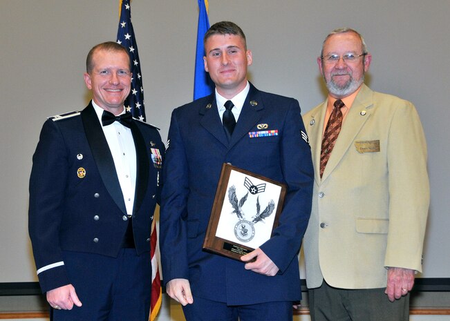 Senior Airman Brendan McMurry, 341st Civil Engineer Squadron, center, receives the Academic Achievement Award at the Airman Leadership School Class 13-F graduation banquet.  Shown presenting the award are Col. Robert W. Stanley II, 341st Missile Wing commander, and Denis Miller, Malmstrom Retiree Association.  The Academic Achievement Award denotes excellence as a scholar and is presented to the student with the highest academic standing, excluding the John L. Levitow Award recipient.  The graduation banquet was held June 11 at the Grizzly Bend.  (U.S. Air Force photo / John Turner)