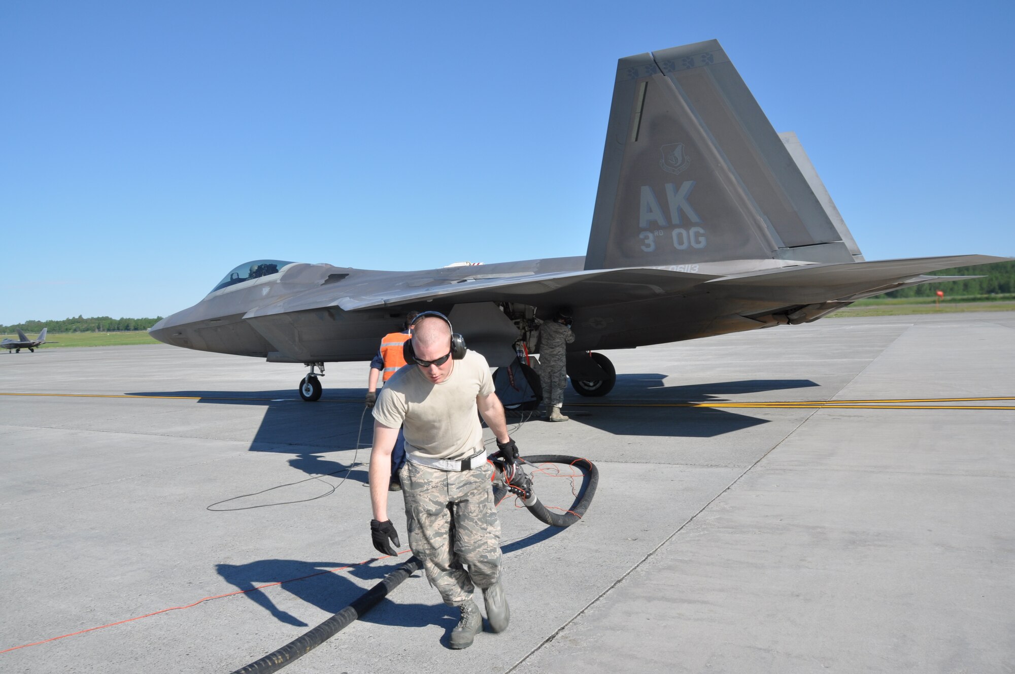 Senior Airman Steven Isaacson, 673rd Logistics Readiness Squadron fuels operator, along with Airmen from the 3rd Aircraft Maintenance Squadron perform a hot pit refuel with an F-22 here. Hot pit refueling is a procedure performed in order to rapidly refuel the aircraft and allow it to complete a second sortie in a short amount of time. During a hot pit refuel the pilot will stay in the cockpit with the jet running while the maintenance crews perform safety checks and refuel the aircraft allowing it to return to flight in minimum. (U.S. Air Force/Capt. Ashley Conner) 