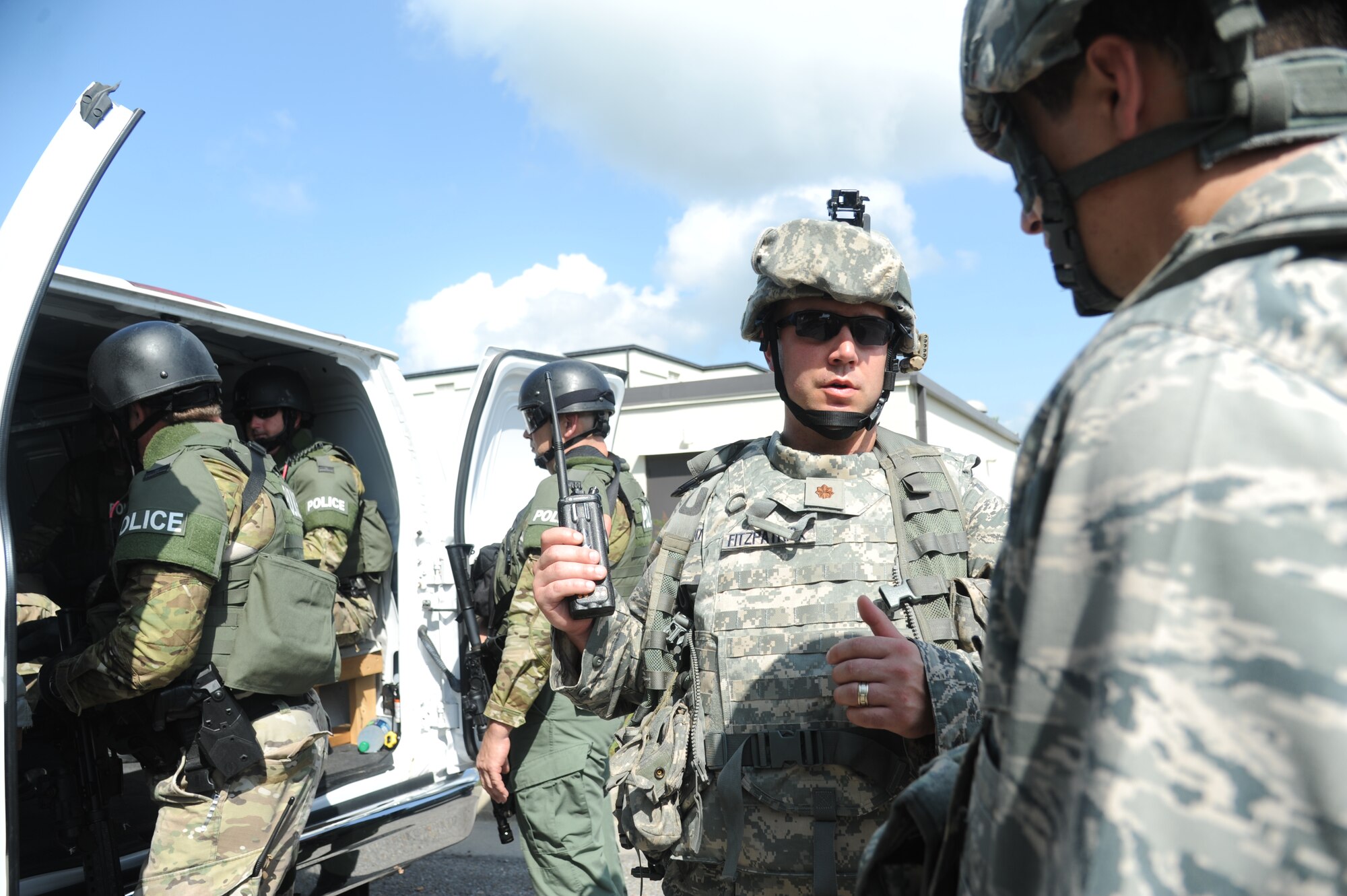 Maj. Brian Fitzpatrick, 81st Security Forces Squadron commander, discusses Biloxi Police Department's special response team’s plan for sweeping the building for portrayed gunmen with Capt. Chris Porta, 81st SFS, during Keesler's active shooter exercise, June 12, 2013, at Garrard Hall, Keesler Air Force Base, Miss.  During the two-day exercise, an Air Force couple simulated opening fire, killing three people and injuring 41.  The exercise tested the base's ability to respond to and recover from a mass casualty event.  (U.S. Air Force photo by Kemberly Groue)