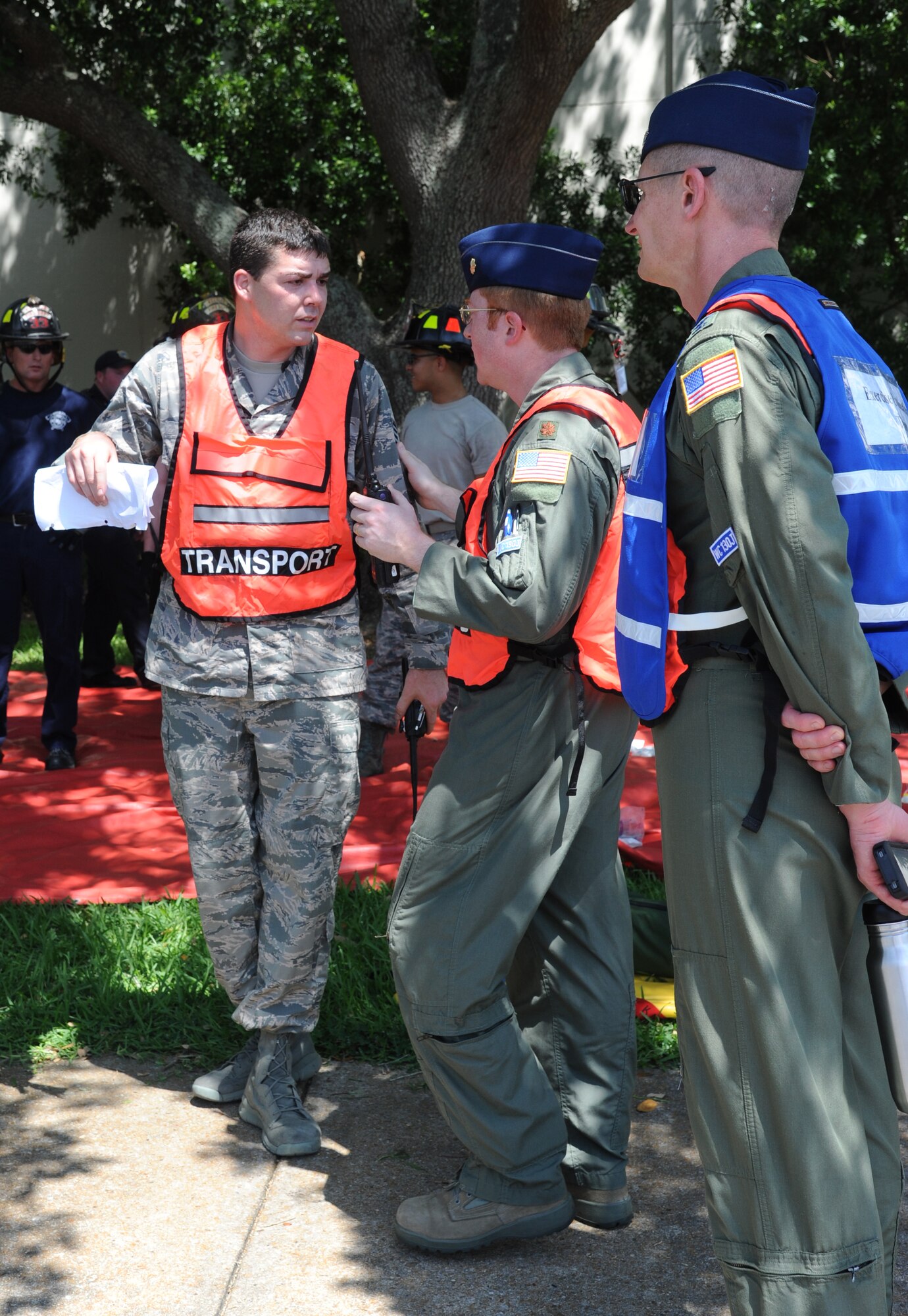 Staff Sgt. Steven Payne, 81st Medical Operations Squadron, and Maj. Shane Steiner, 81st Aerospace Medicine Squadron and medical on-scene commander, discuss transportation of the “victims” from the scene to the Keesler Medical Center as Col. Paul Nelson, 81st Aerospace Medicine Squadron and exercise evaluation team member stands by to evaluate them during Keesler's active shooter exercise, June 12, 2013, at Garrard Hall, Keesler Air Force Base, Miss.  During the two-day exercise, an Air Force couple simulated opening fire killing three people and injuring 41.  The exercise tested the base's ability to respond to and recover from a mass casualty event.  (U.S. Air Force photo by Kemberly Groue)