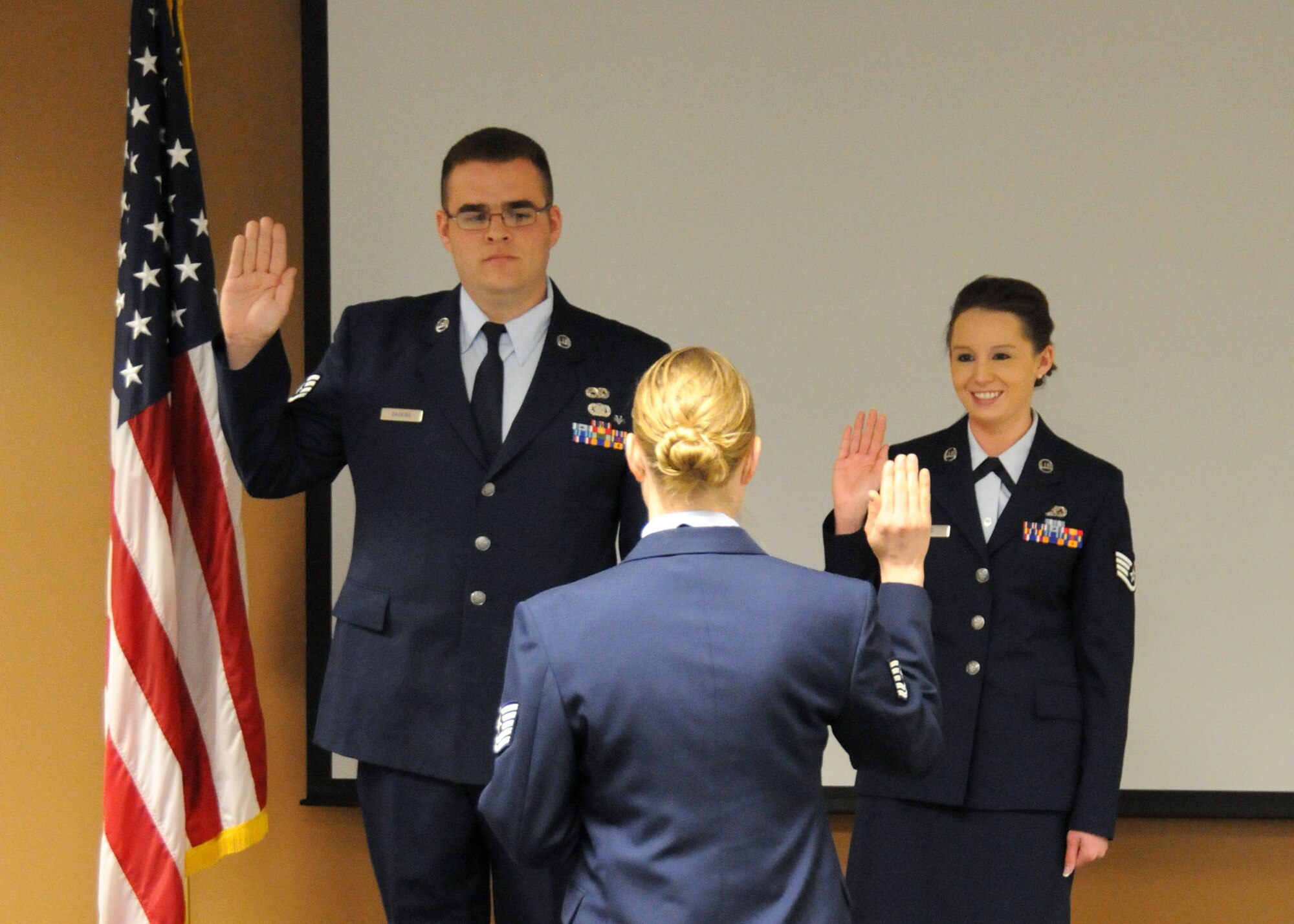 Tech. Sgt. Tammy Wajer, 120th Maintenance Operations Squadron member, leads Staff Sgt. Jack Gaskins, 120th Logistics Readiness Squadron member, and Staff Sgt. Paige Held, 120th Force Support Squadron member, in the recitation of their oath during the NCO Induction Ceremony held at the 120th Fighter Wing on April 7. (U.S. Air Force Photo/Senior Master Sgt. Eric Peterson)