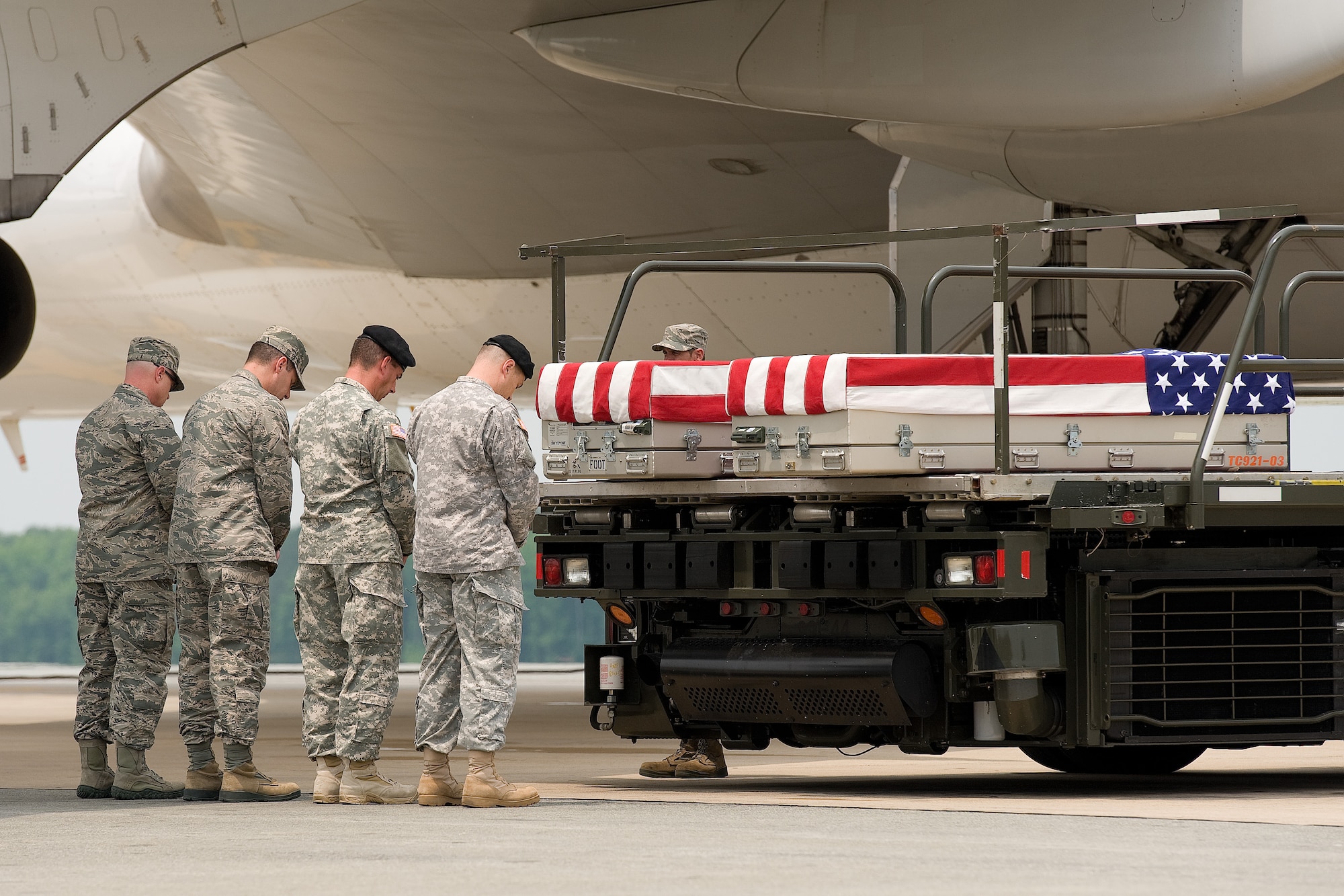 Air Force Chaplain (Maj.) Kevin Hopkins, Air Force Mortuary Affairs Operations, says a prayer in honor of Army Lt. Col. Todd J. Clark, right, of Evans Mills, N.Y., and Maj. Jaimie E. Leonard, left, of Warrick, N.Y., at Dover Air Force Base, Del., June 12, 2013. Both were assigned to the Headquarters and Headquarters Company, 2nd Brigade Combat Team, 10th Mountain Division, Fort Drum, N.Y. Chaplains march toward the aircraft with the official party to say a prayer at the beginning of a dignified transfer. Hopkins is deployed to the mortuary from the 190th Refueling Wing, Kansas Air National Guard. (U.S. Air Force photo/Roland Balik)