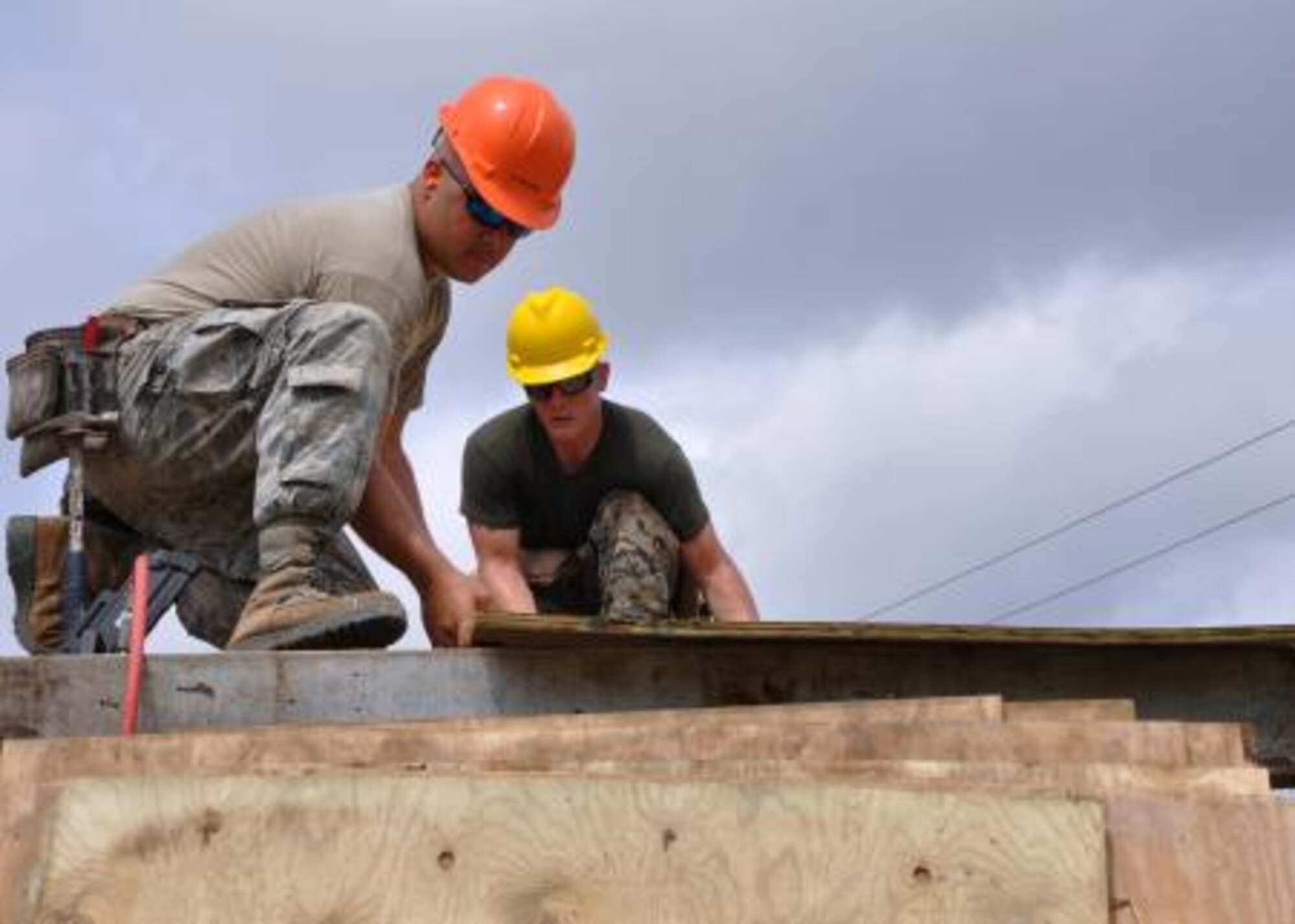 U.S. Air Force Staff Sgt. John McAllister, left, structures craft lead for Crooked Tree Government Primary School from the 823rd RED HORSE Squadron, places roof decking with U.S. Marine Corps Cpl. Brett Harden, combat engineer from the Marine Wing Support Squadron 471, to repair a roof at Hattieville Government Pre-School June 4, 2013 as part of an exercise called New Horizons. Using excess building materials, the civil engineers plan to repair the leaky roof. Civil Engineers from both the U.S. and Belize are constructing various structures at schools throughout Belize as part of an exercise called New Horizons. Building these facilities will support further education for the children of the country and provide valuable training for U.S. and Belizean service members. (U.S. Air Force photo/Capt. Holly Hess)
