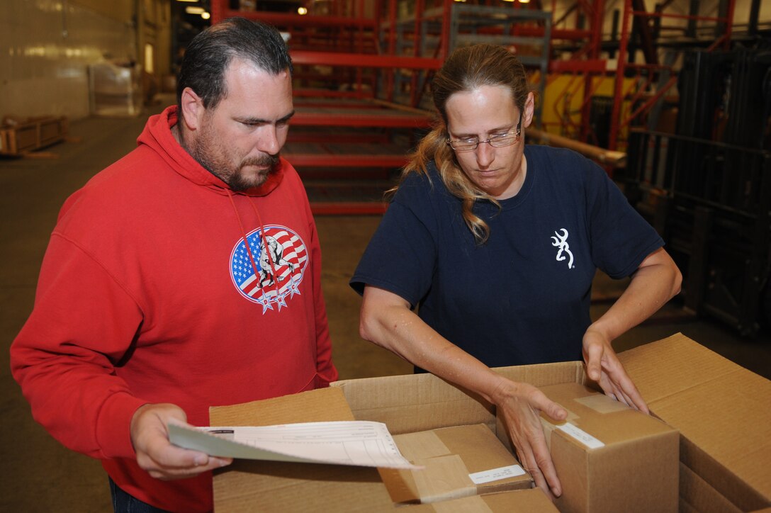 Christy Wolfe, 28th Civil Engineer Squadron material controls supply technician, inspects equipment with Ed Malone, National General Supply contractor, while receiving new parts for the Material Controls warehouse on Ellsworth Air Force Base, S.D., June 6, 2013. Each part received by the supply technicians is inspected and matched to the order form to ensure all parts are accounted for and available for use as soon as possible. (U.S. Air Force photo by Senior Airman Kate Maurer/Released)