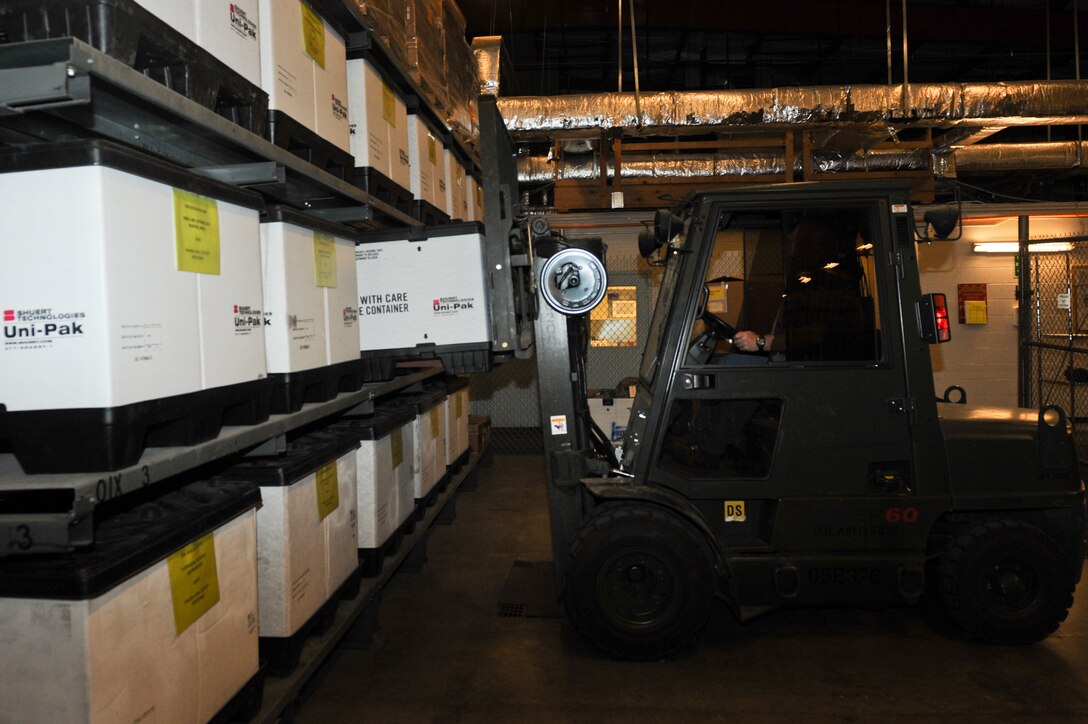 Jason DeCoster, 28th Civil Engineer Squadron material controls supply technician, stores a crate of parkas during a routine inventory in the material controls warehouse on Ellsworth Air Force Base, S.D., June 6, 2013. There are 25 parkas per crate, each containing a different size of coat that are stored until next winter or until more Airmen are assigned to the 28th CES. (U.S. Air Force photo by Senior Airman Kate Maurer/Released)