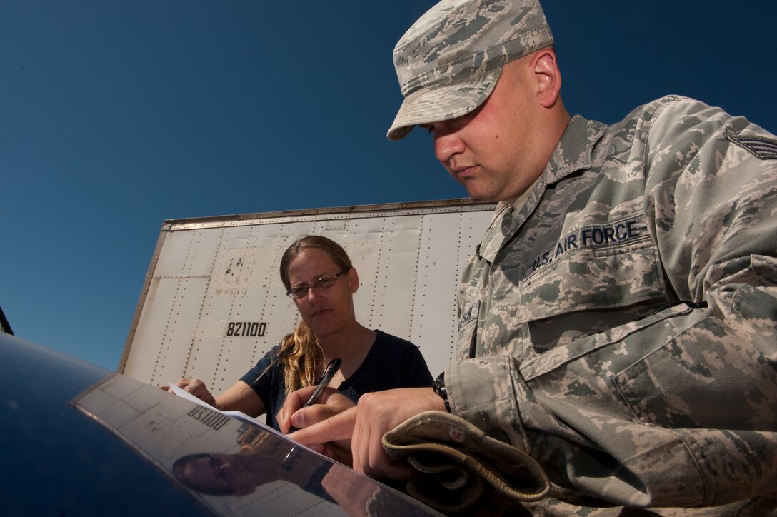 Staff Sgt. Gordon Williamson, 28th Civil Engineer Squadron heavy equipment technician, completes paperwork for Christy Wolfe, 28th CES material controls supply technician, after loading a truck with street sweeper parts at the Material Controls warehouse on Ellsworth Air Force Base, S.D., May 8, 2013. Aside from providing Airmen with parts to complete work orders, Material Controls Airmen supply the 28th CES with uniform items unique to their job, such as the 100 percent-cotton uniforms for fire protection Airmen, as well as chemical protection gear and deployment equipment. (U.S. Air Force photo by Senior Airman Kate Maurer/Released)