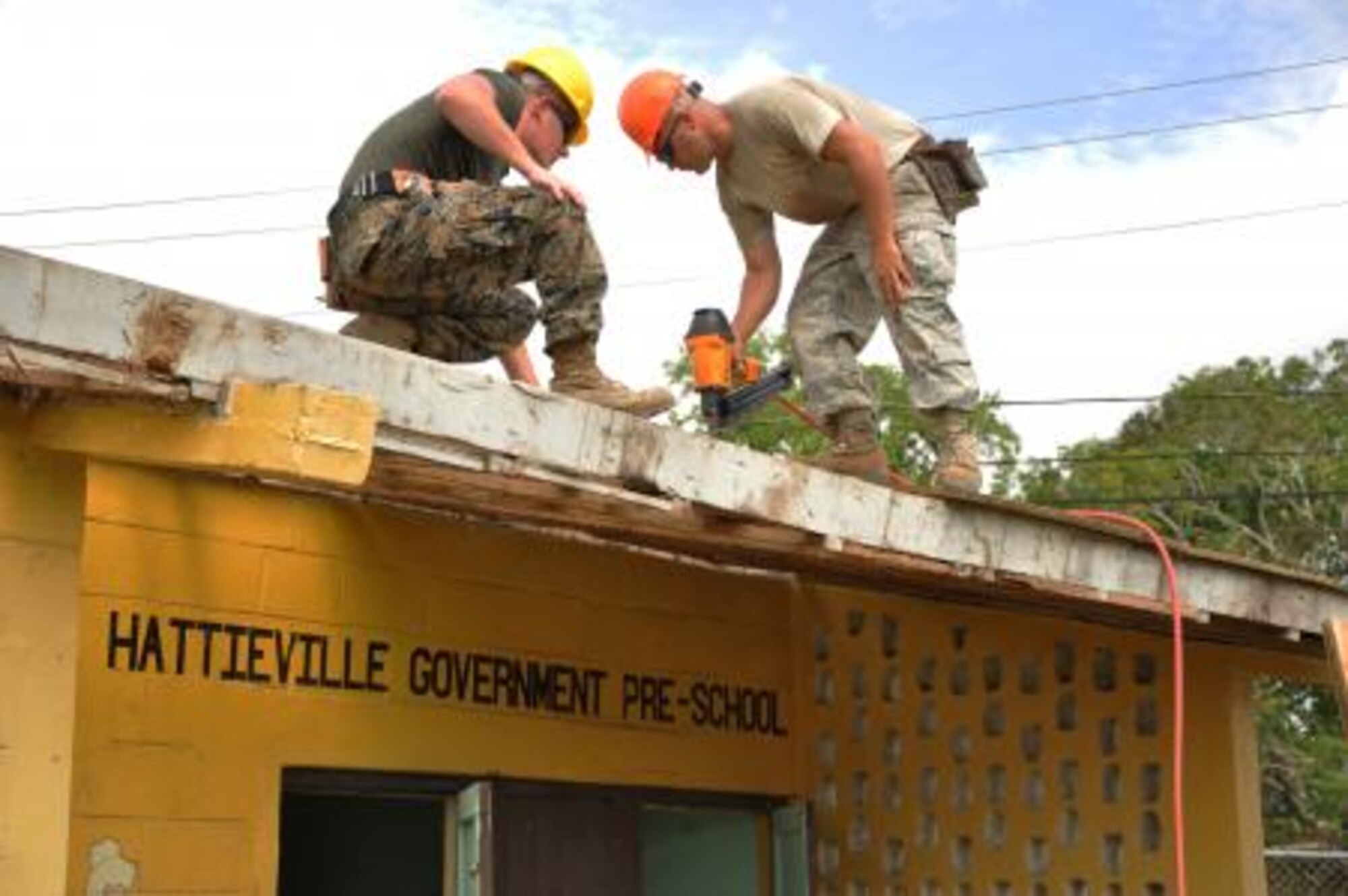 U.S. Air Force Staff Sgt. John McAllister, right, structures craft lead for Crooked Tree Government Primary School from the 823rd RED HORSE Squadron, and U.S. Marine Corps Cpl. Brett Harden, combat engineer from the Marine Wing Support Squadron 471, work together to install roof decking to repair a roof at Hattieville Government Pre-School June 4, 2013, as part of an exercise called New Horizons. Using excess building materials, the civil engineers plan to repair the leaky roof. Civil Engineers from both the U.S. and Belize are constructing various structures at schools throughout Belize as part of an exercise called New Horizons. Building these facilities will support further education for the children of the country and provide valuable training for U.S. and Belizean service members. (U.S. Air Force photo/Capt. Holly Hess)





